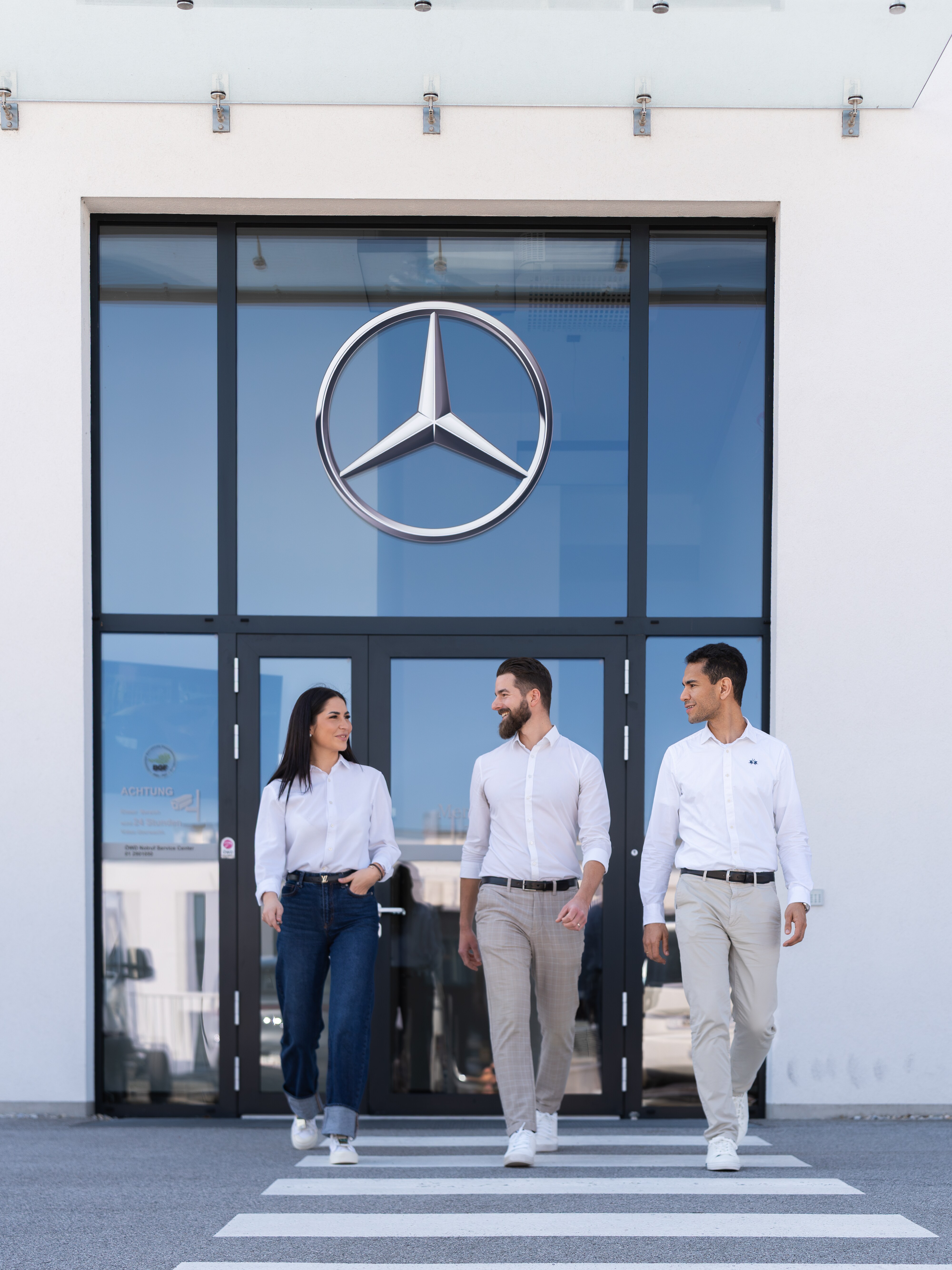 Eine Gruppe von Menschen gehen von einem Mercedes Standort weg.