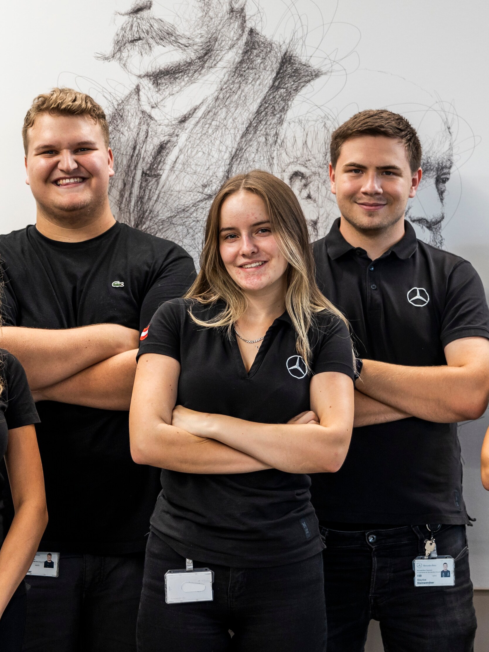 Ein Team, das zusammen vor einem Porträt posieren.