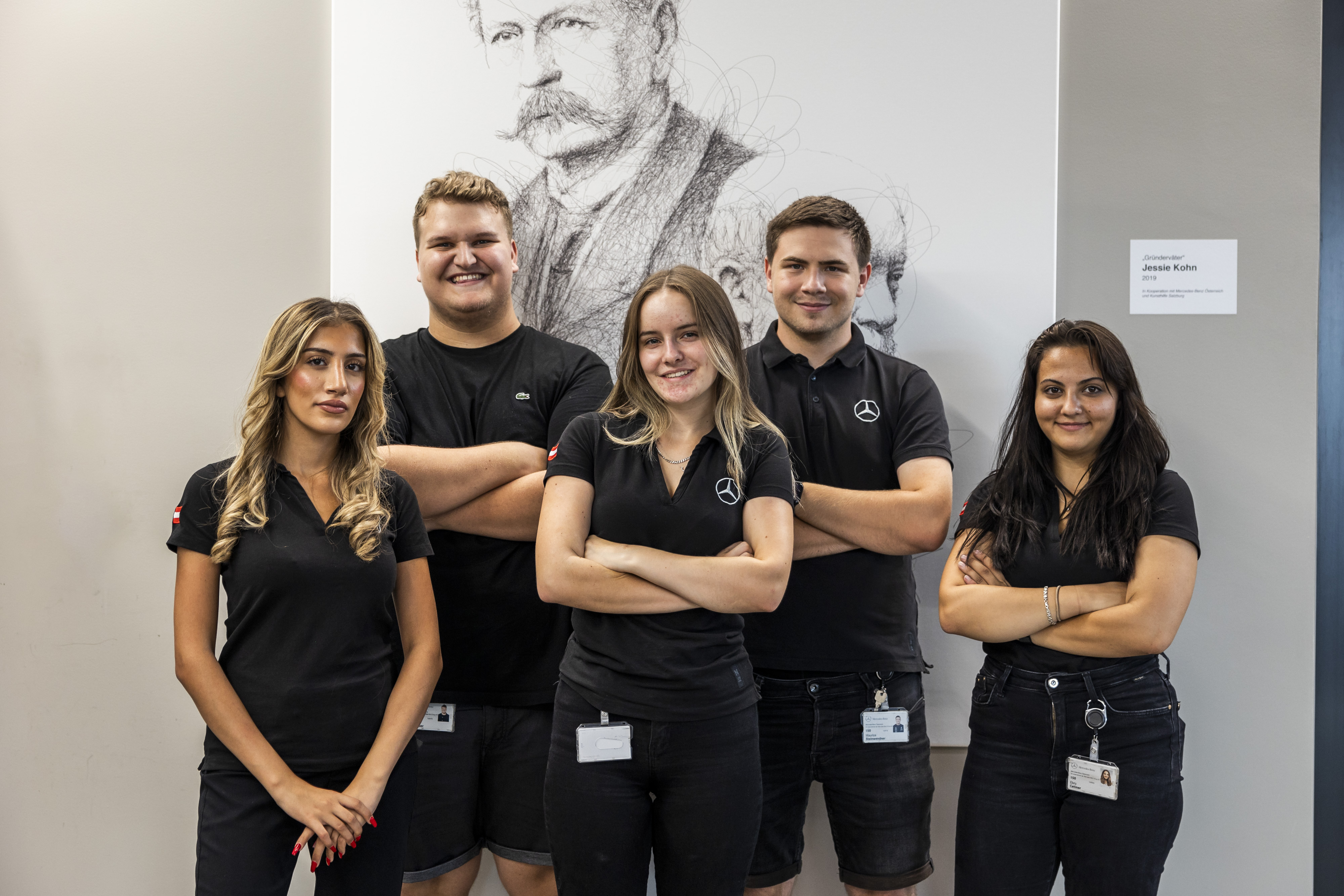 Lehre bei Mercedes-Benz Ein Team, das zusammen vor einem Porträt posieren.