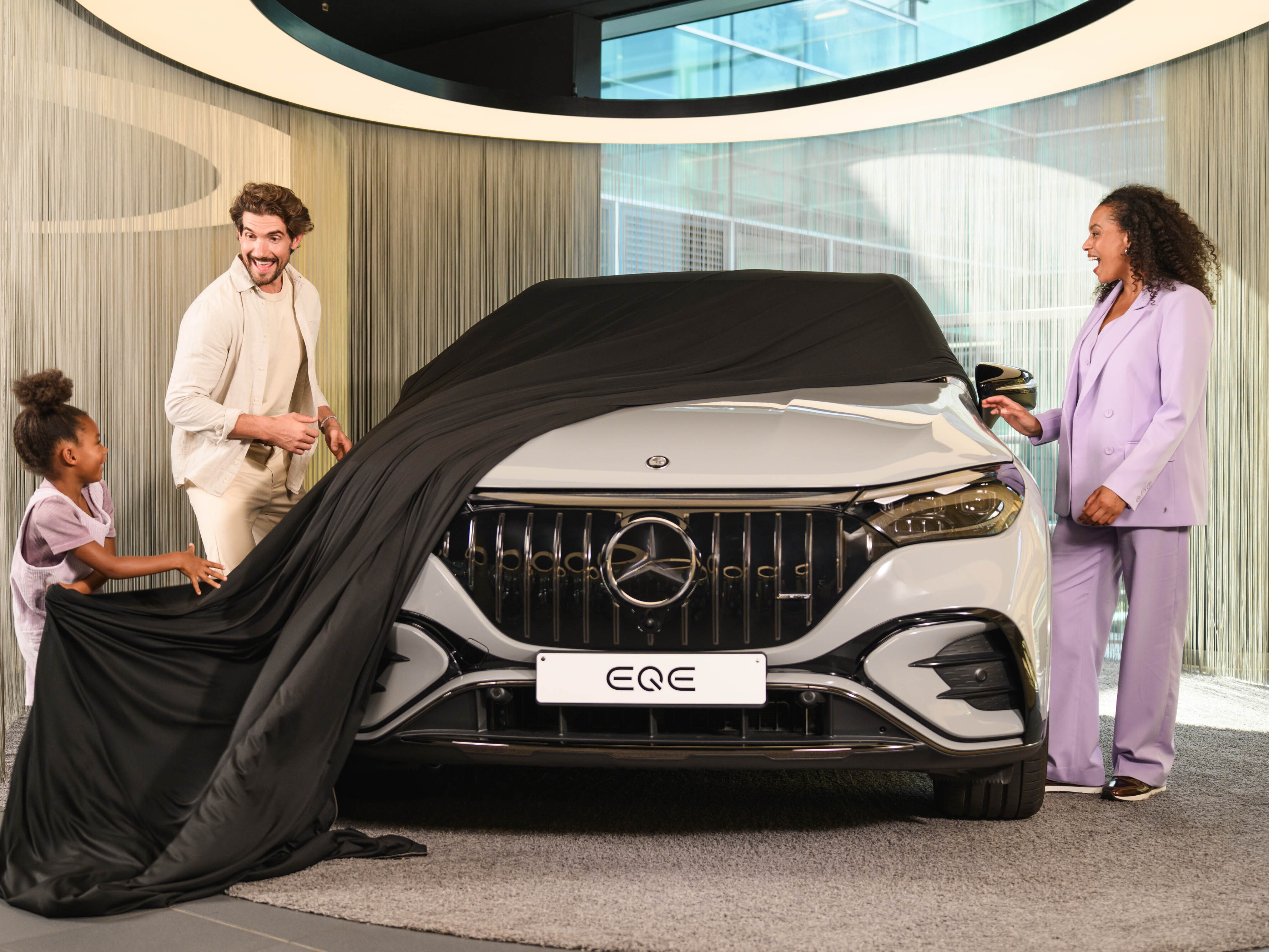 Eine Familie mit einem Kind enthüllt ihren neuen Mercedes-Benz