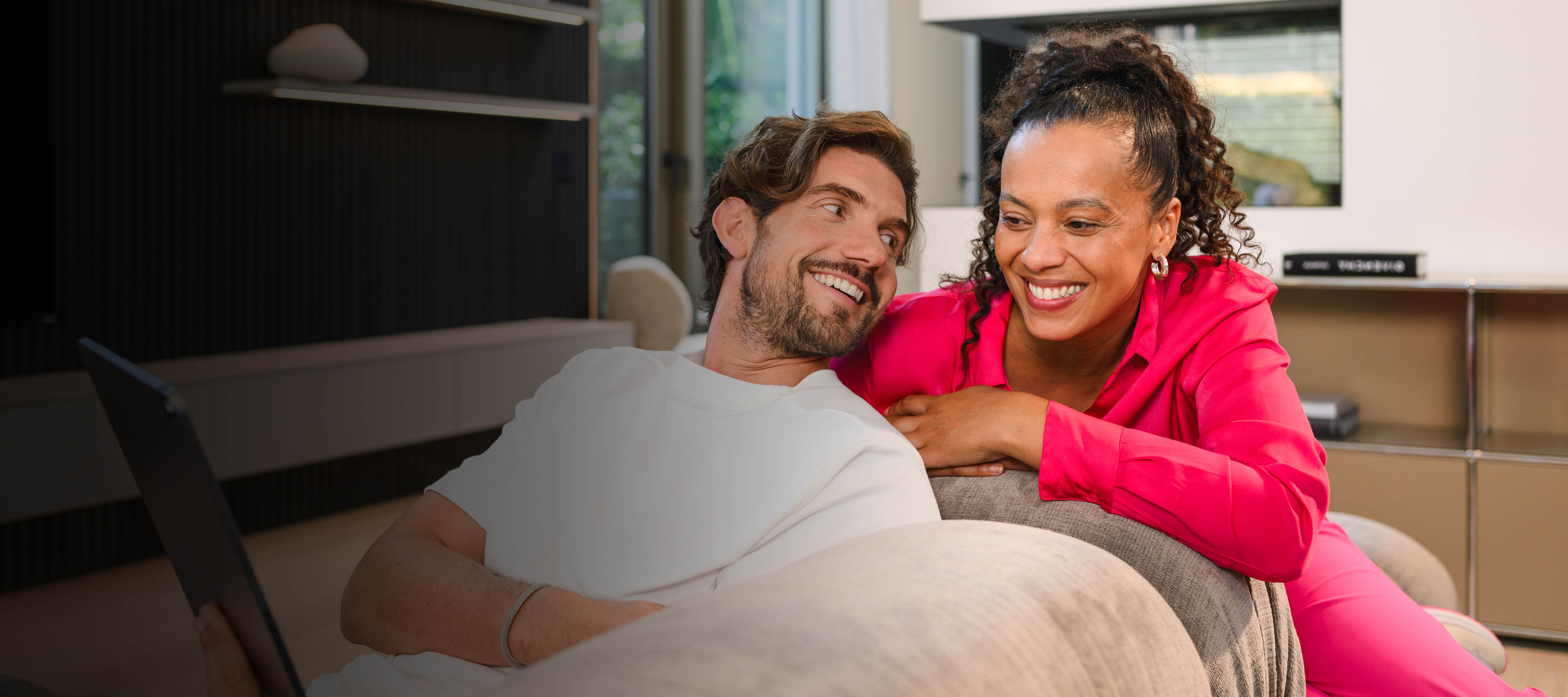 Leasing & Finanzierung | Finanzdienstleistungen | Mercedes-Benz Zwei Personen sitzen auf einem Sofa und betrachten ein mobiles Gerät.