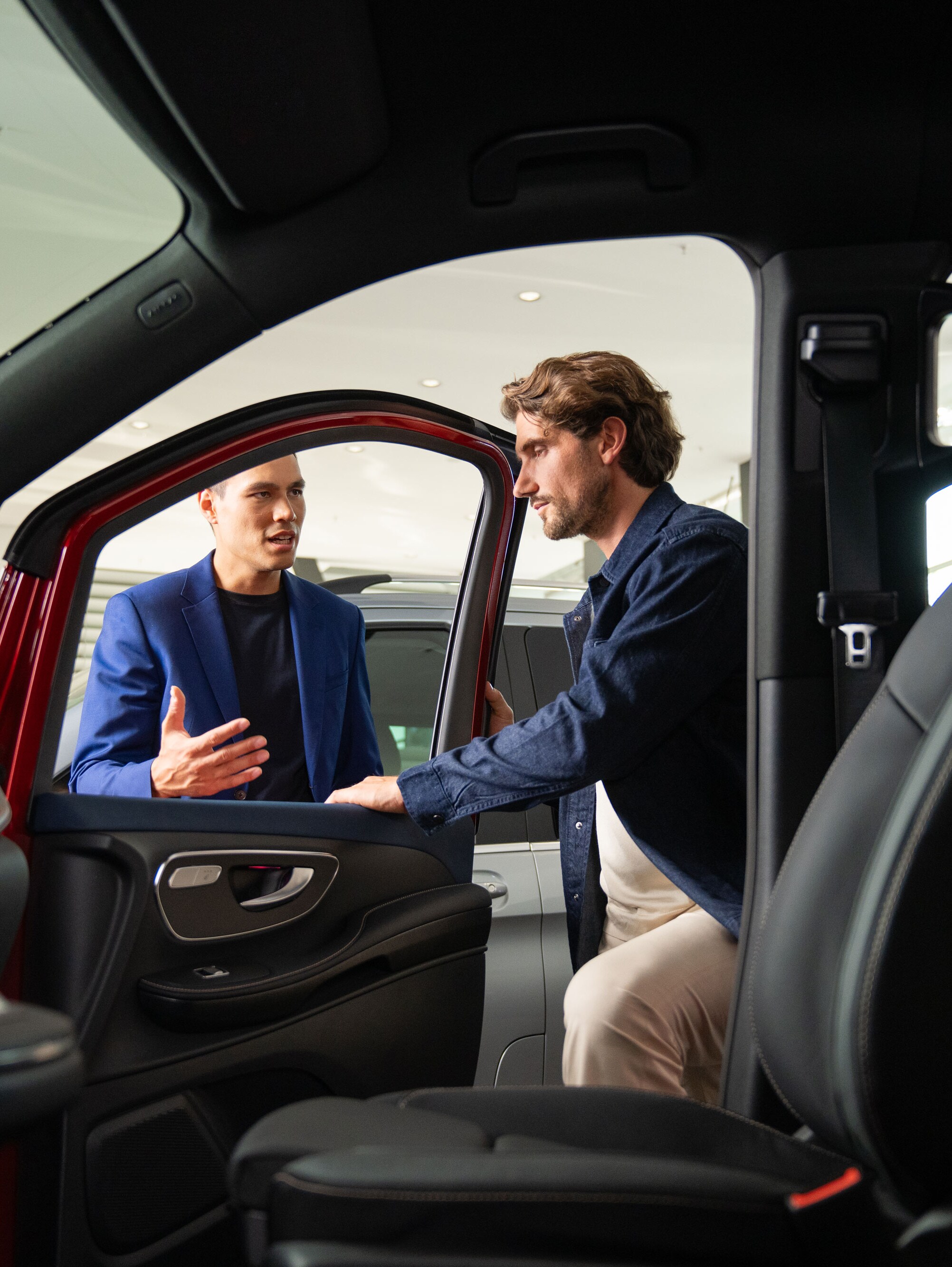 Eine Aufnahme aus dem Innenraum, die zwei Personen zeigt, die die Beifahrertür öffnen.