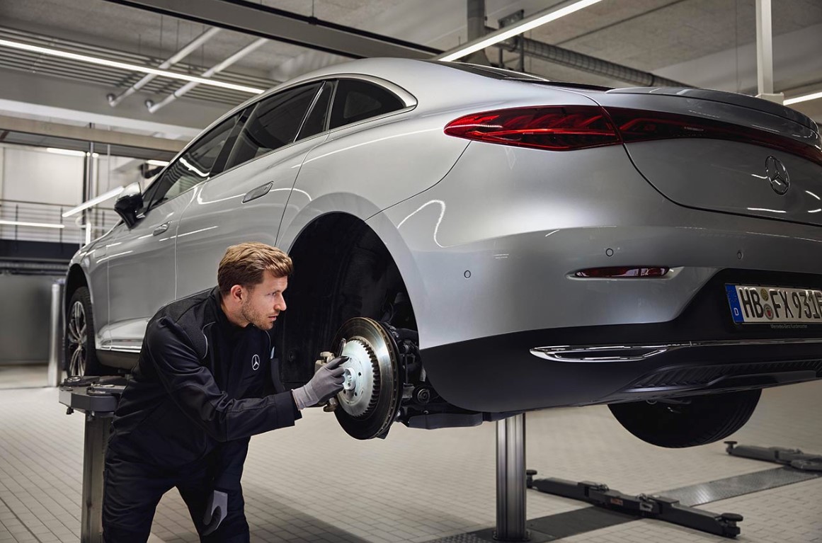 Original-Bremsenersatz von Mercedes-Benz Ein Mercedes-Benz-Fahrzeug steht auf einer Hebebühne, während ein Techniker die hintere Bremsanlage im Rahmen eines Austauschs von Originalteilen überprüft.
