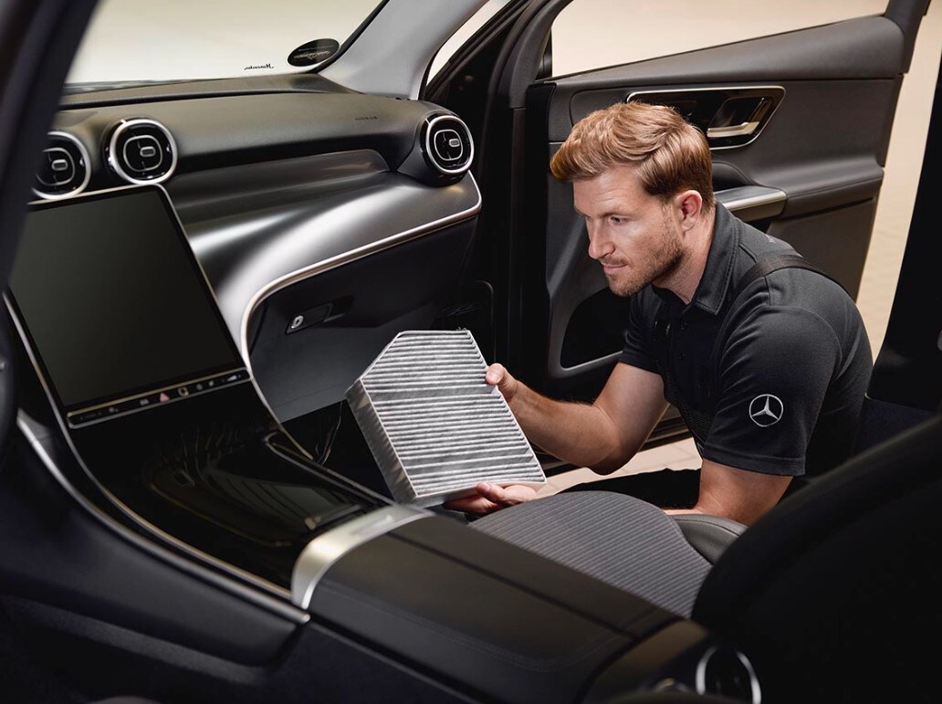 Servicearbeiten im Interieur zeigen den Austausch eines Innenraumfilters unter Verwendung eines Originalteils von Mercedes-Benz.