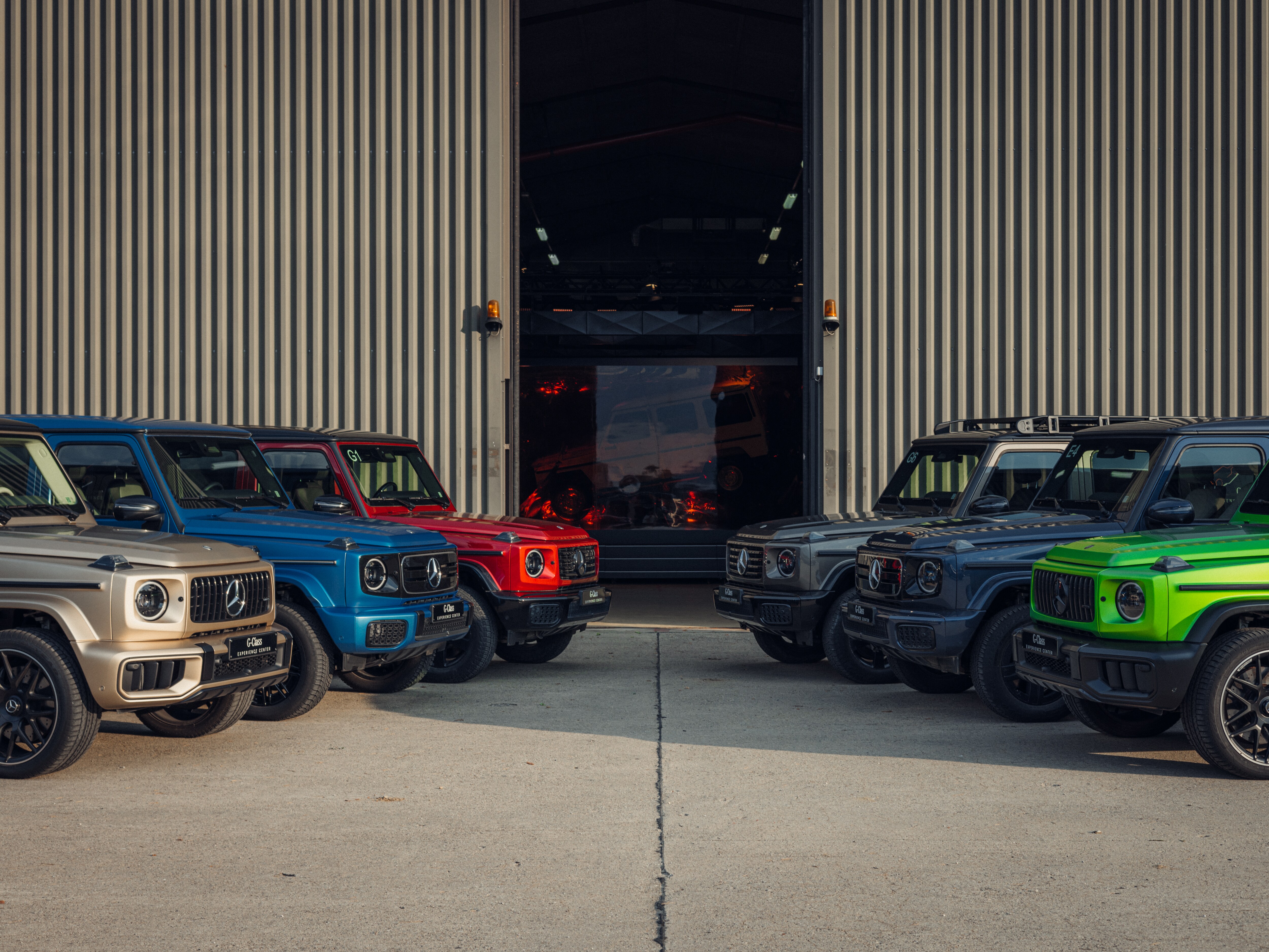 G-Klasse in verschiedenen Farben vor Werk