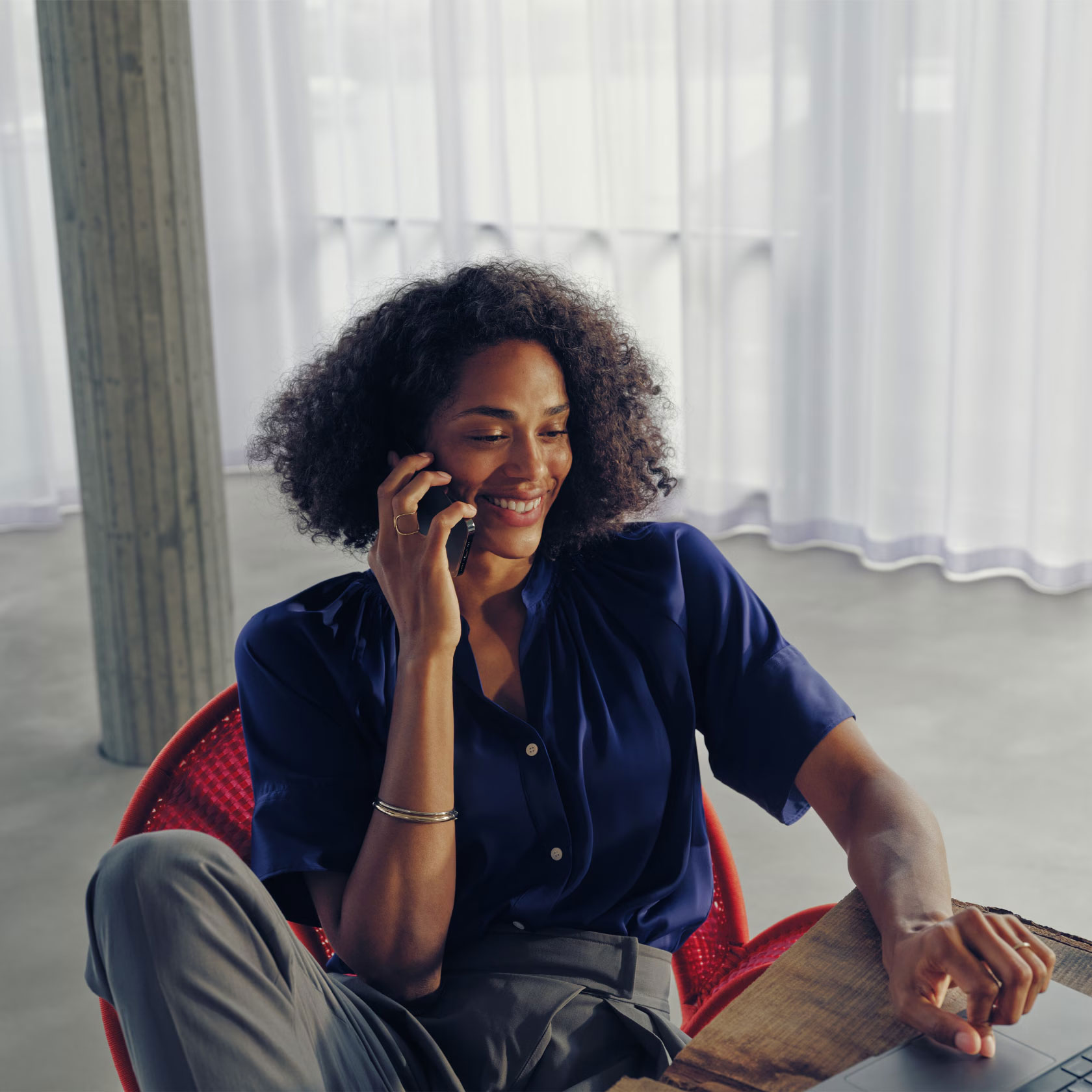Mercedes-Benz Store | Mercedes-Benz. Eine Frau sitzt auf einem Sessel und telefoniert.