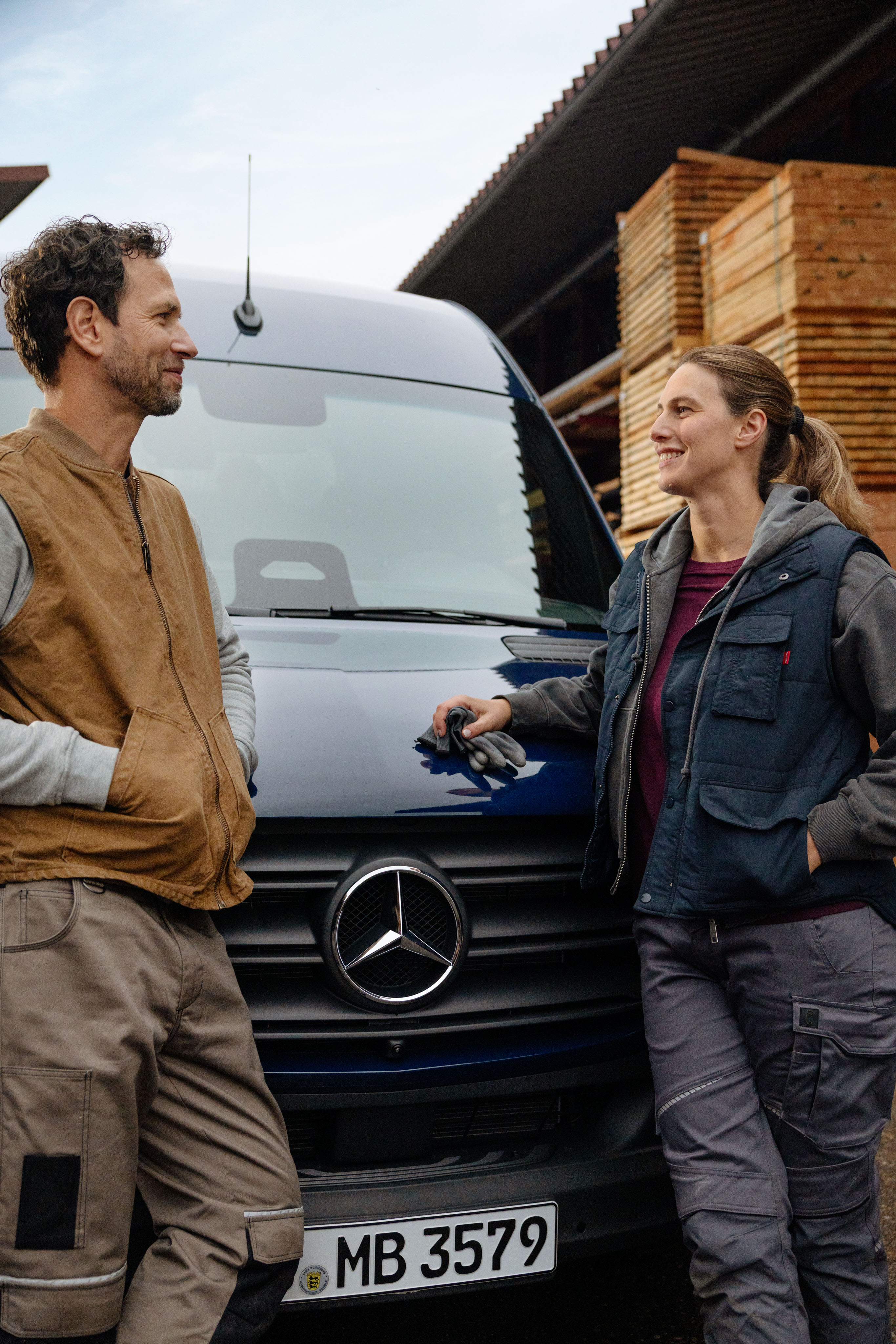 Mercedes-Benz | Sprinter. Eine Person steht mit einer anderen vor einem SPrinter.