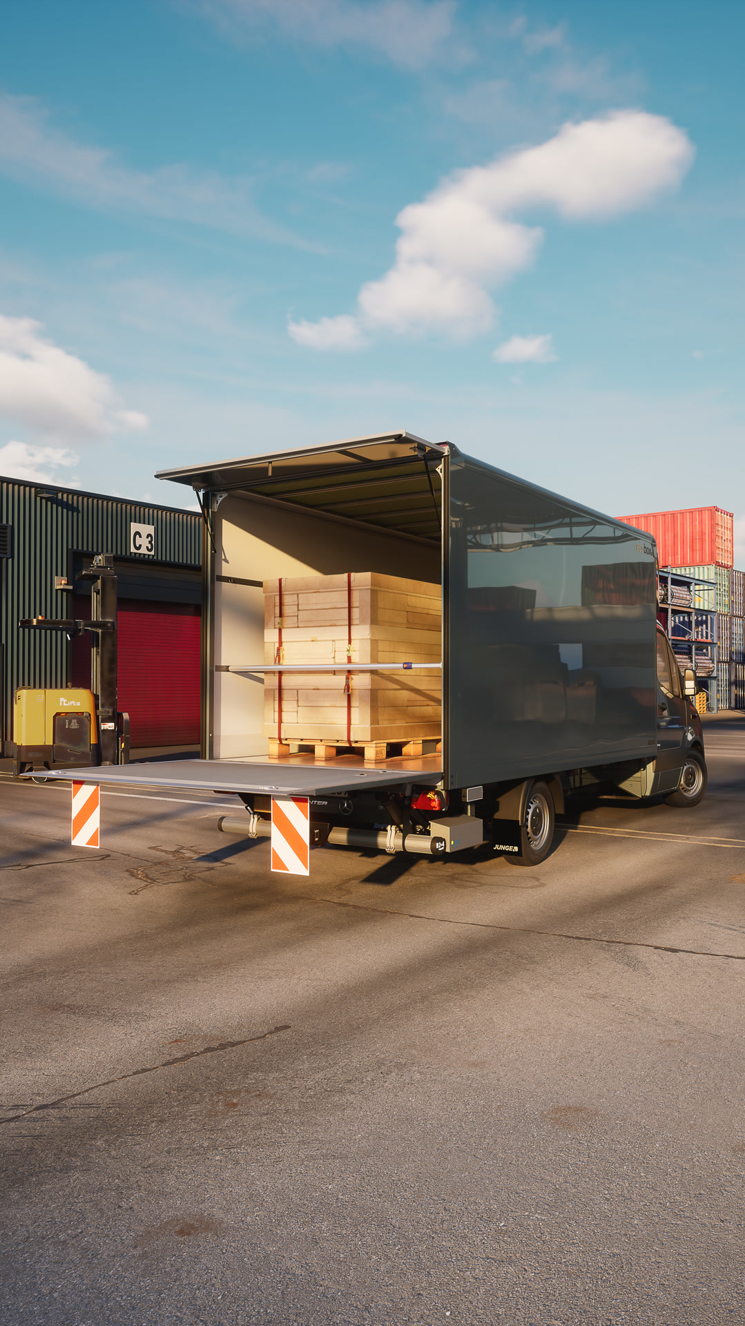 Mercedes‑Benz Sprinter mit Trockenfrachtkoffer‑Aufbau von Junge bei der Beladung im Logistikzentrum – effiziente Transportlösung für Stückgut und Warenverkehr. Die geöffnete Heckklappe zeigt palettierte Holzplatten im Laderaum während der Be‑ oder Entladung.