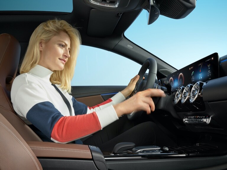 Eine Frau bedient die digitalen Extras in der Head-Unit ihres Fahrzeugs.