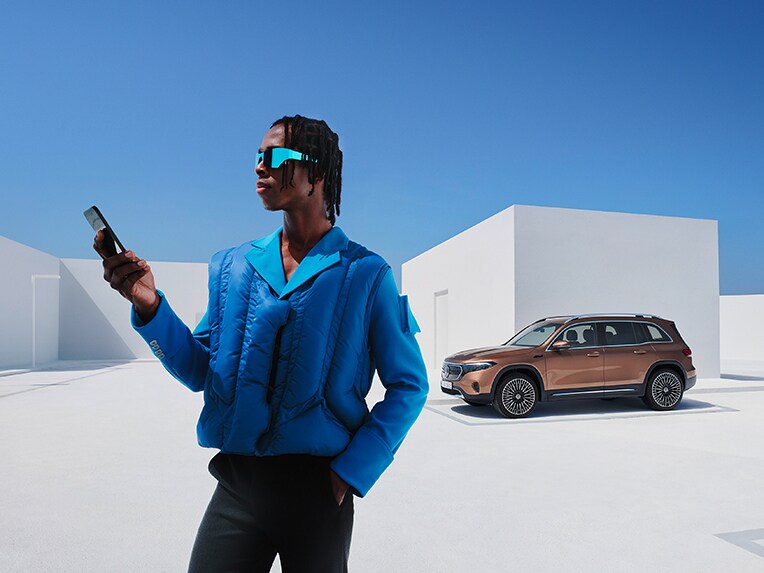 Ein Mann ist mit seinem Smartphone mit dem Mercedes-Benz verknüpft.