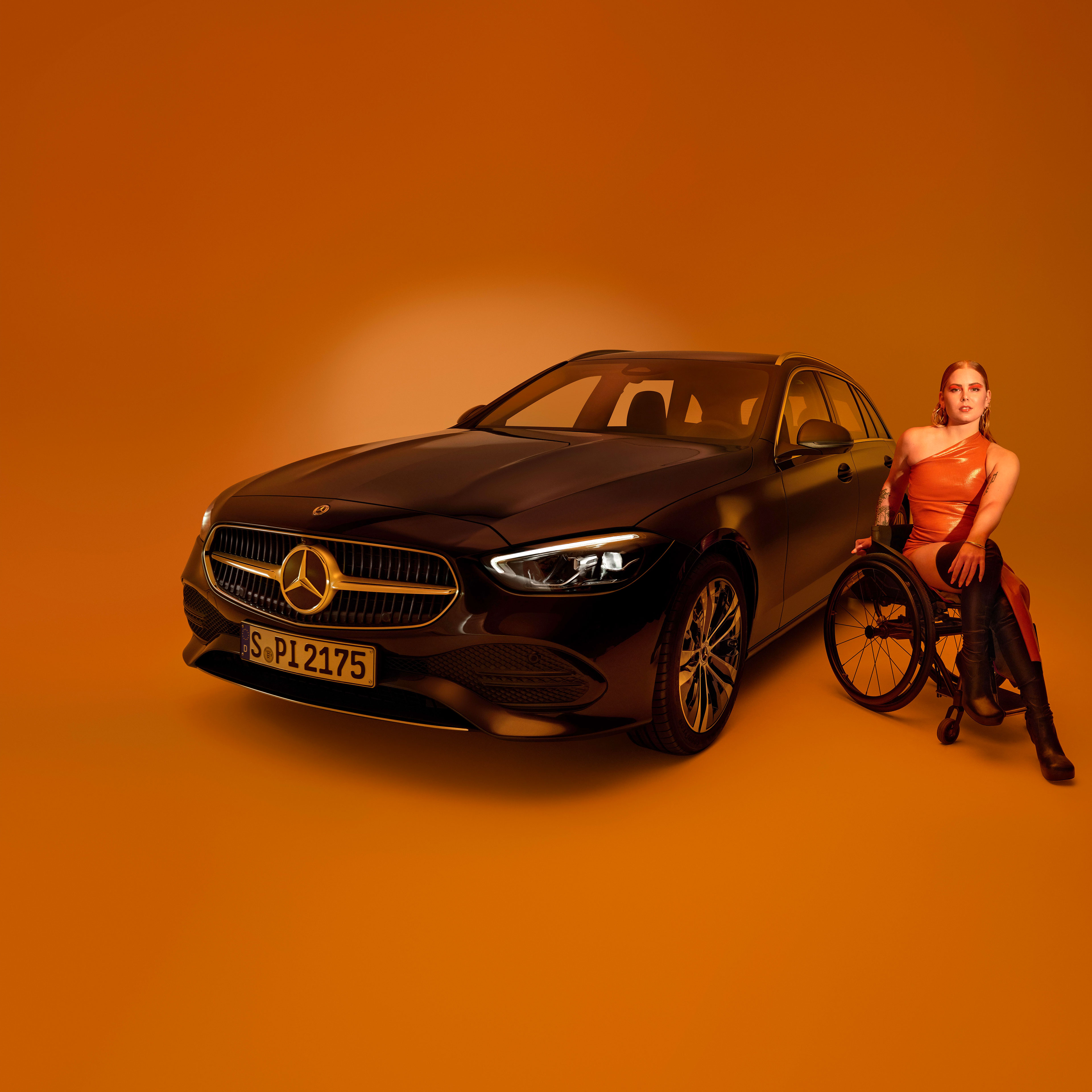 Fahrhilfen | Mercedes-Benz Das Exterieur einer als behindertengerechtes Auto umgebauten C-Klasse T-Modell und eine Frau im Rollstuhl.