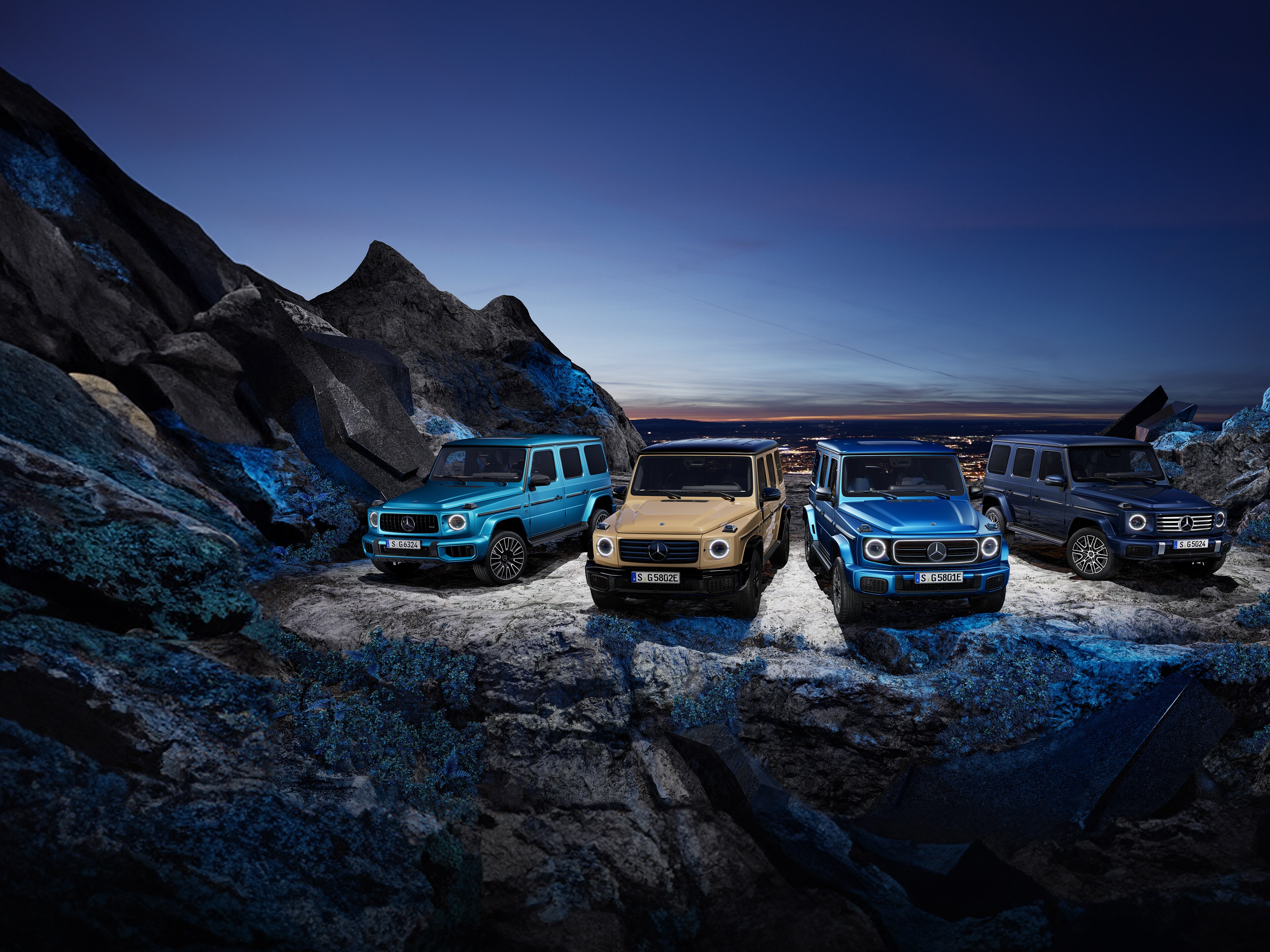 Drei Mercedes-Benz G-Klassen stehen auf einer Klippe.