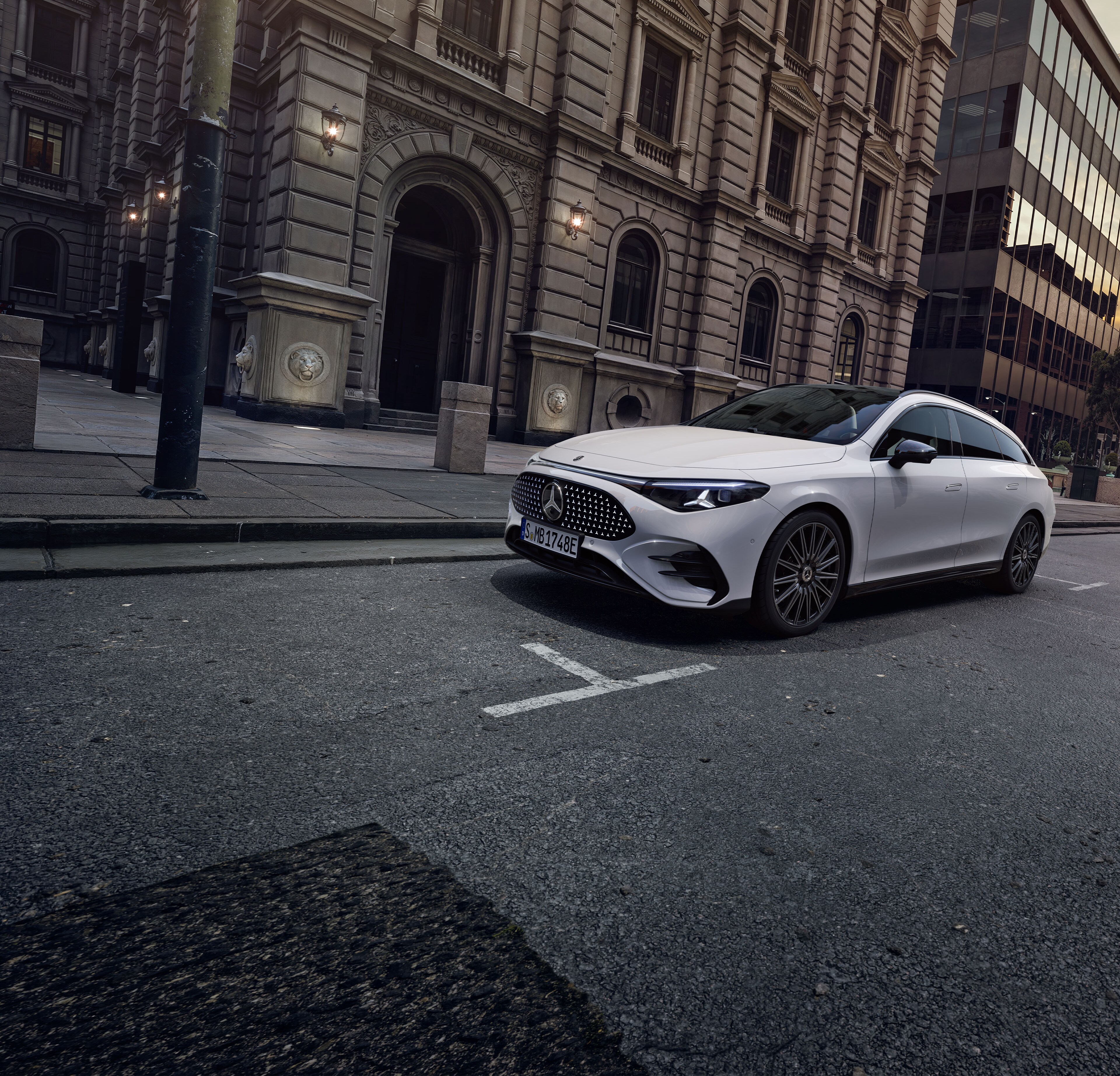 Ein weißer, vollelektrischer CLA Shooting Brake vor einer detailreichen Fassade.