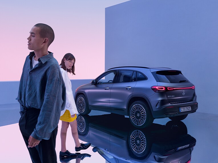Zwei Personen stehen vor einem Mercedes-Benz PKW