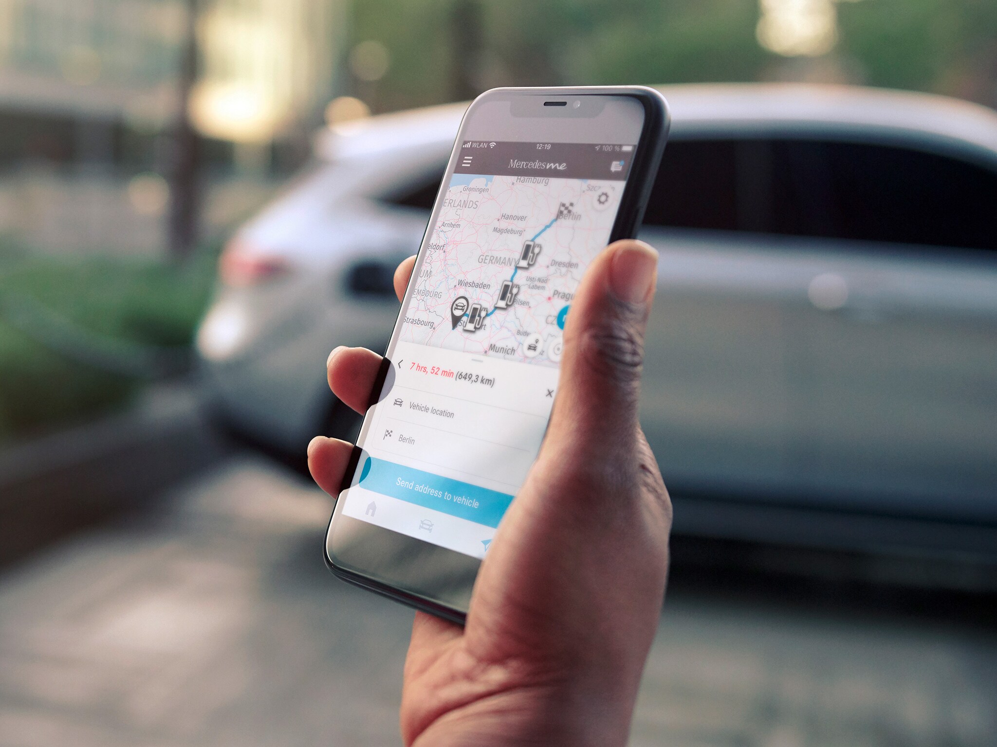 Eine Hand hält ein Smartphone um eine Route zu planen 