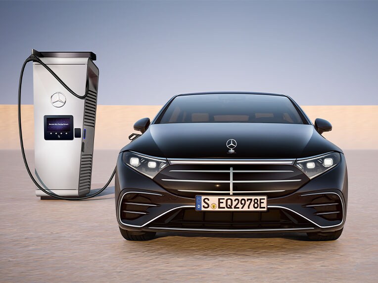 Frontansicht der EQS Limousine von Mercedes-Benz ladend an einer öffentlichen Ladesäule.