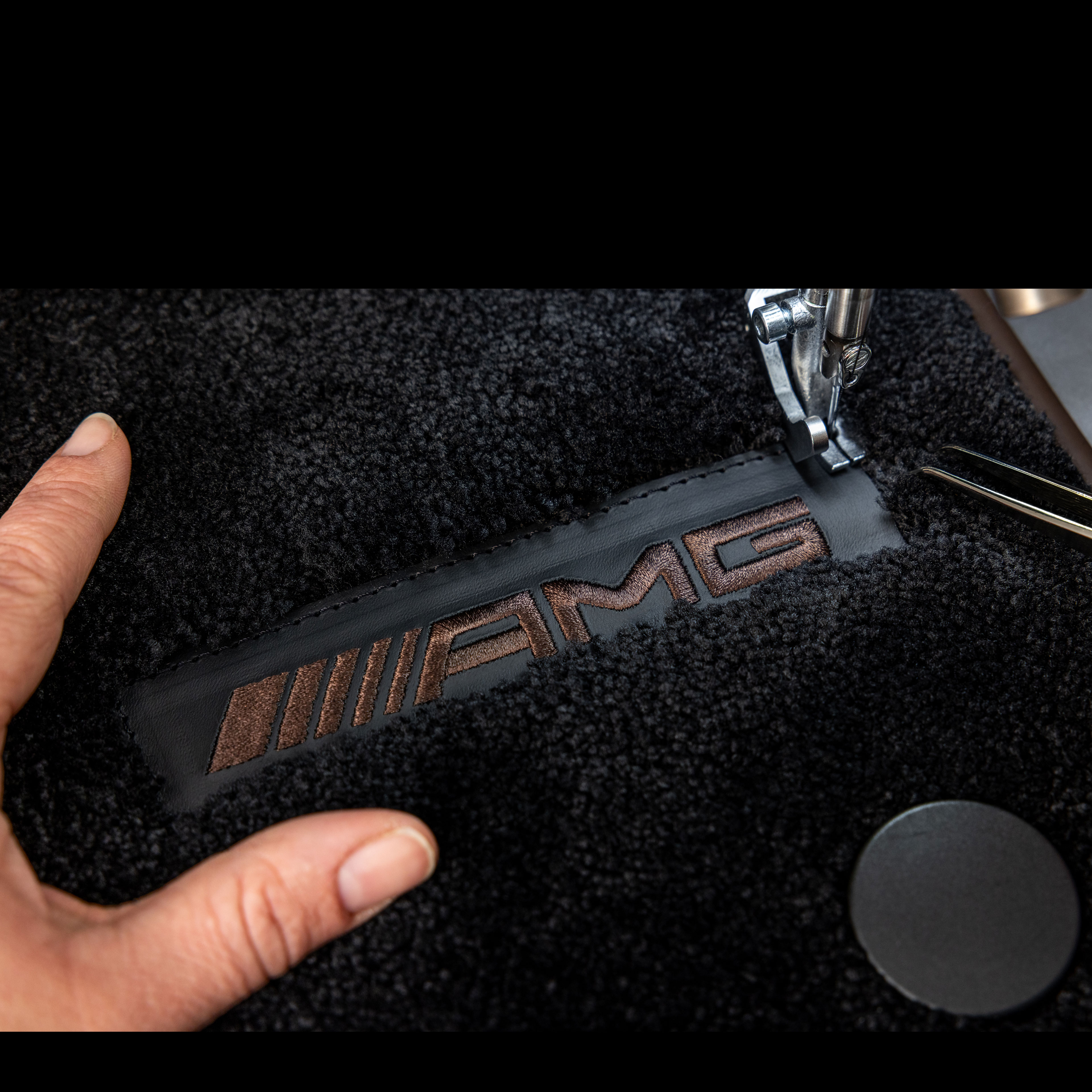 MANUFAKTUR | Mercedes-AMG MANUFAKTUR Schriftzug auf dunkler Fläche in einem Mercedes-AMG.