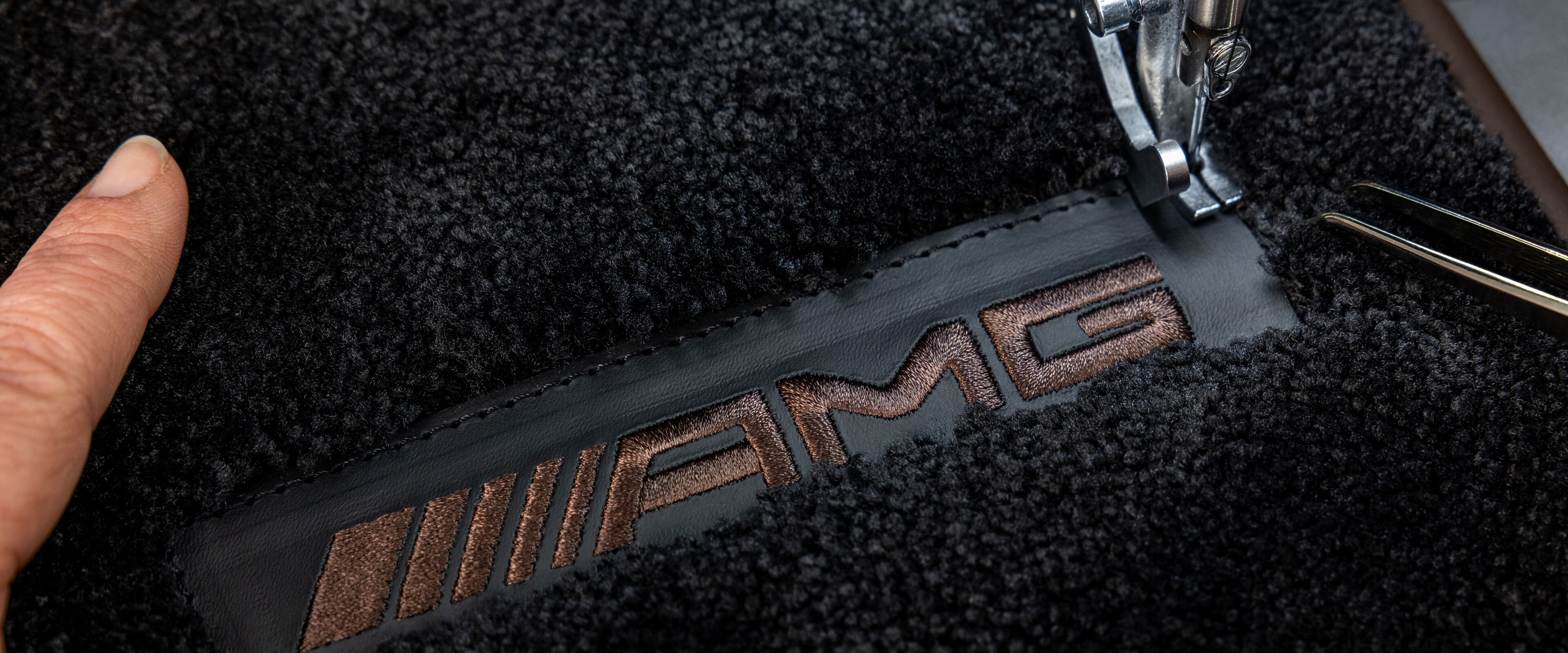 MANUFAKTUR Schriftzug auf dunkler Fläche in einem Mercedes-AMG.