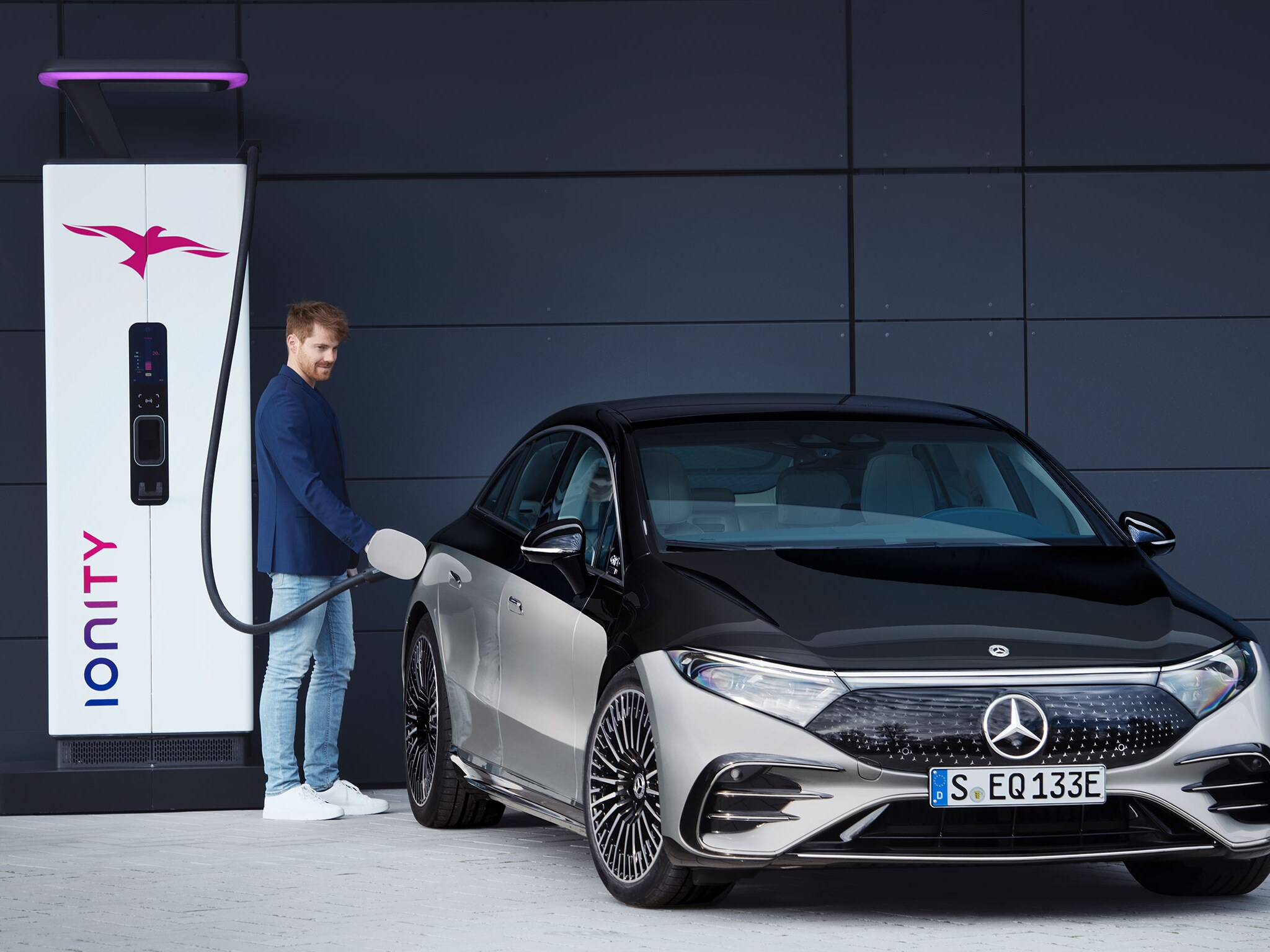 Ein Mercedes-Benz EQS lädt an einer Ionity-Ladestation vor blauem Hintergrund