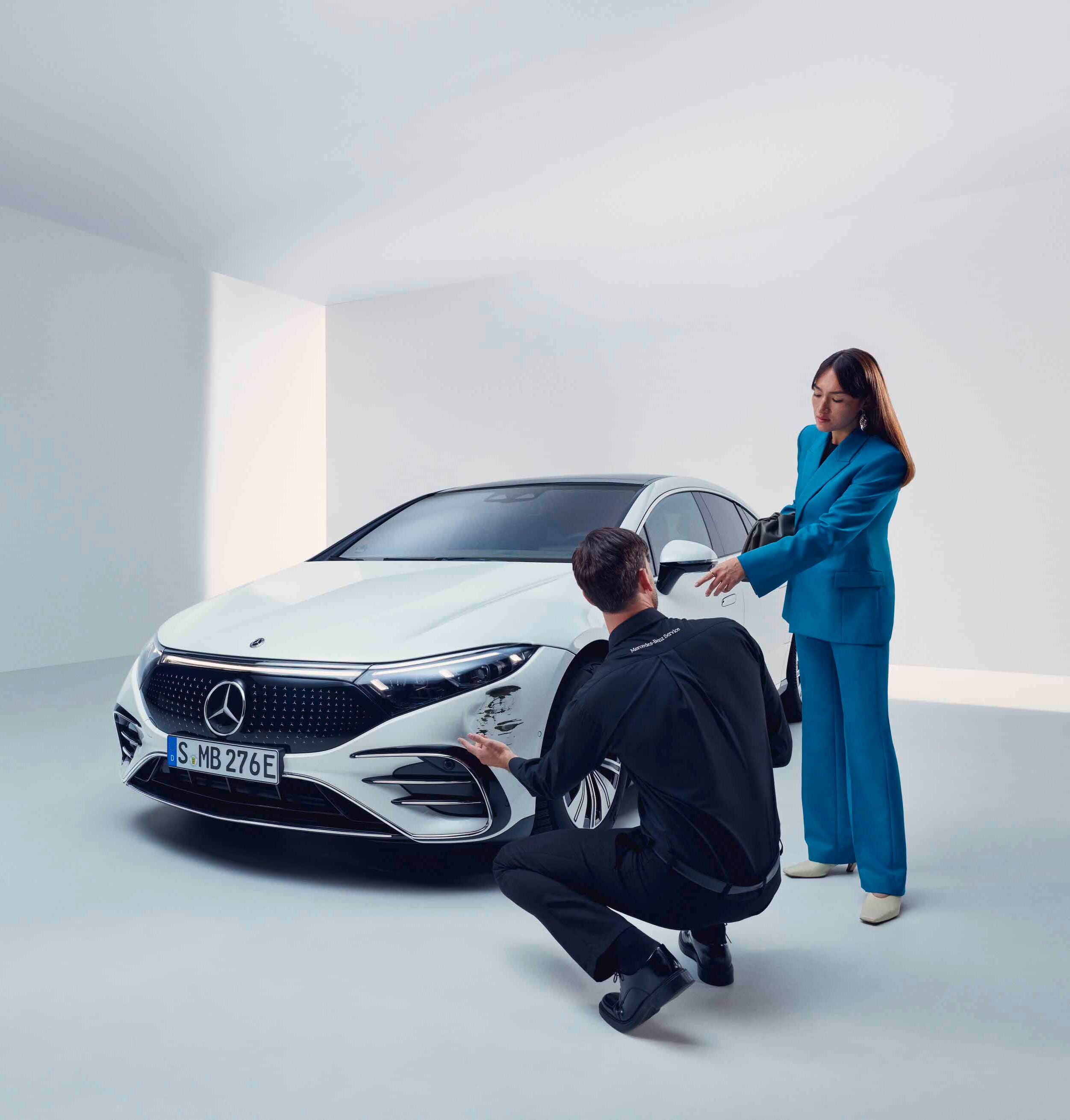 Eine Frau lässt ihren Mercedes-Benz von einem Servicemitarbeiter begutachten.