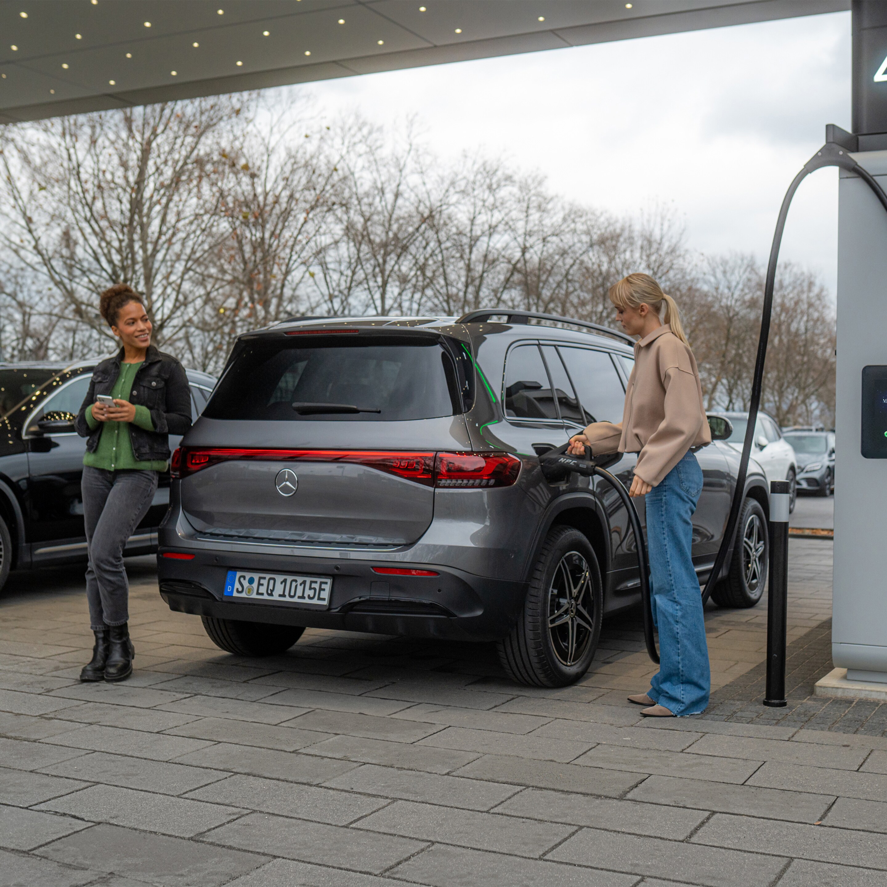 Zwei Mercedes-Benz Elektroautos an einer Ladestation.