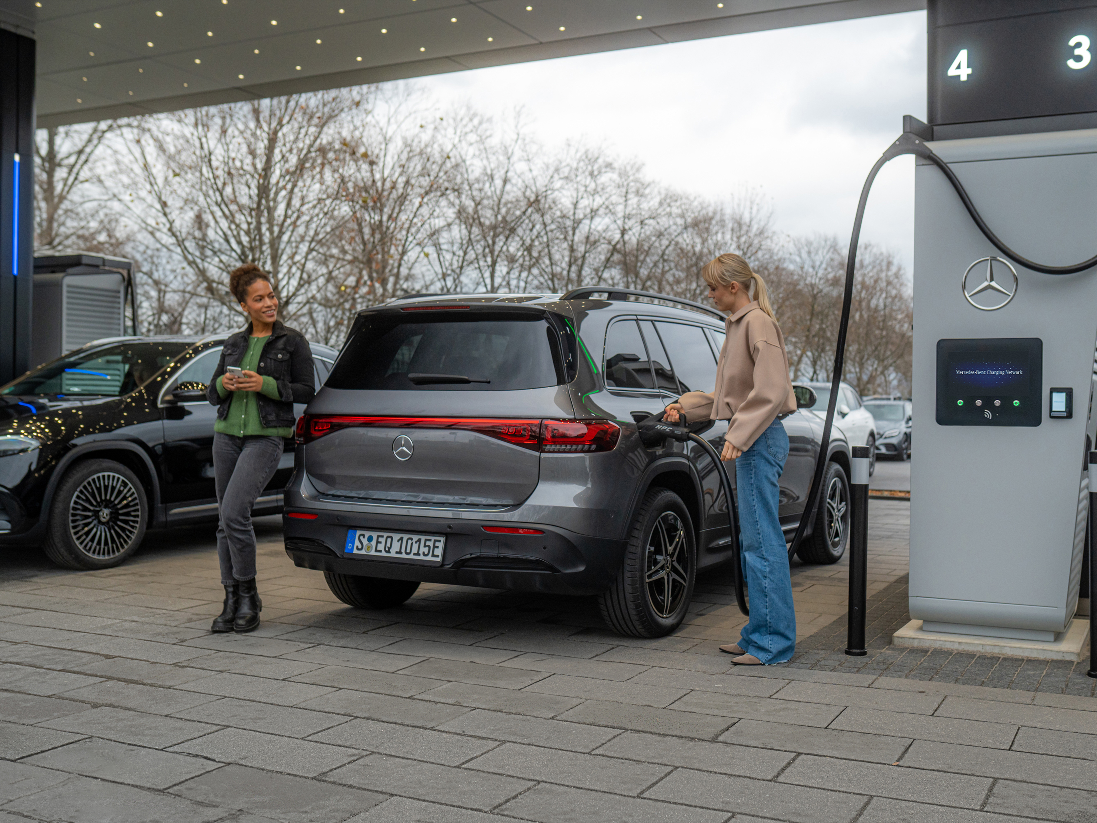 Mercedes-Benz Charging Network | Laden unterwegs | Mercedes-Benz Zwei Mercedes-Benz Elektroautos an einer Ladestation.