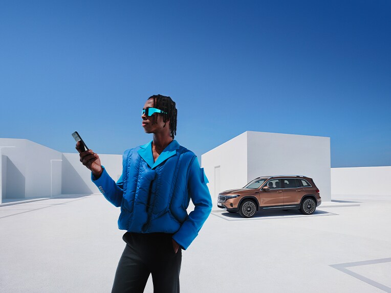 Ein Mann ist mit seinem Smartphone mit dem Mercedes-Benz verknüpft.