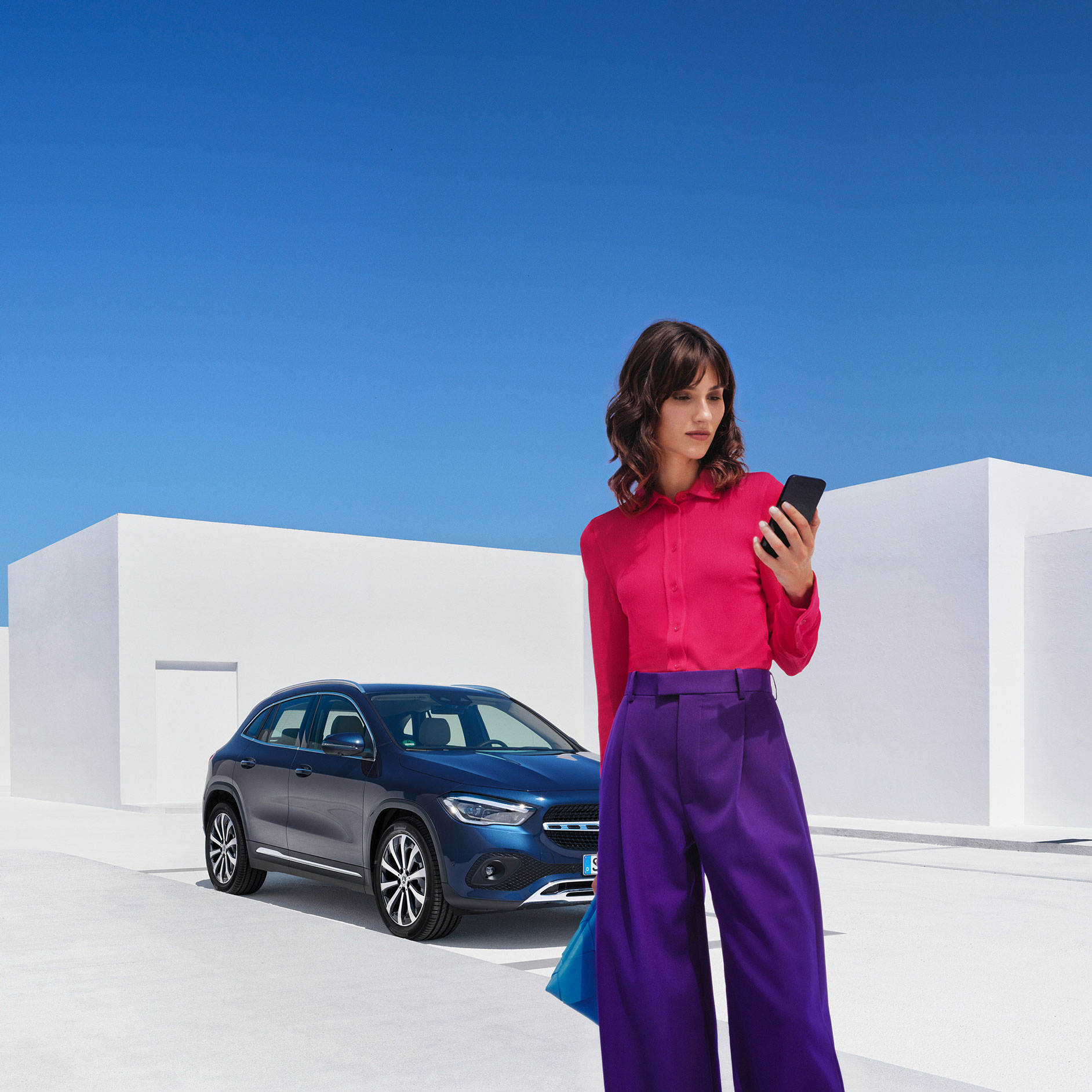 Mercedes me App | Mercedes me ID | Mercedes me Eine Frau verbindet sich per Smartphone, der Mercedes me App und Ihrer Mercedes me ID mit ihrem Mercedes Benz.