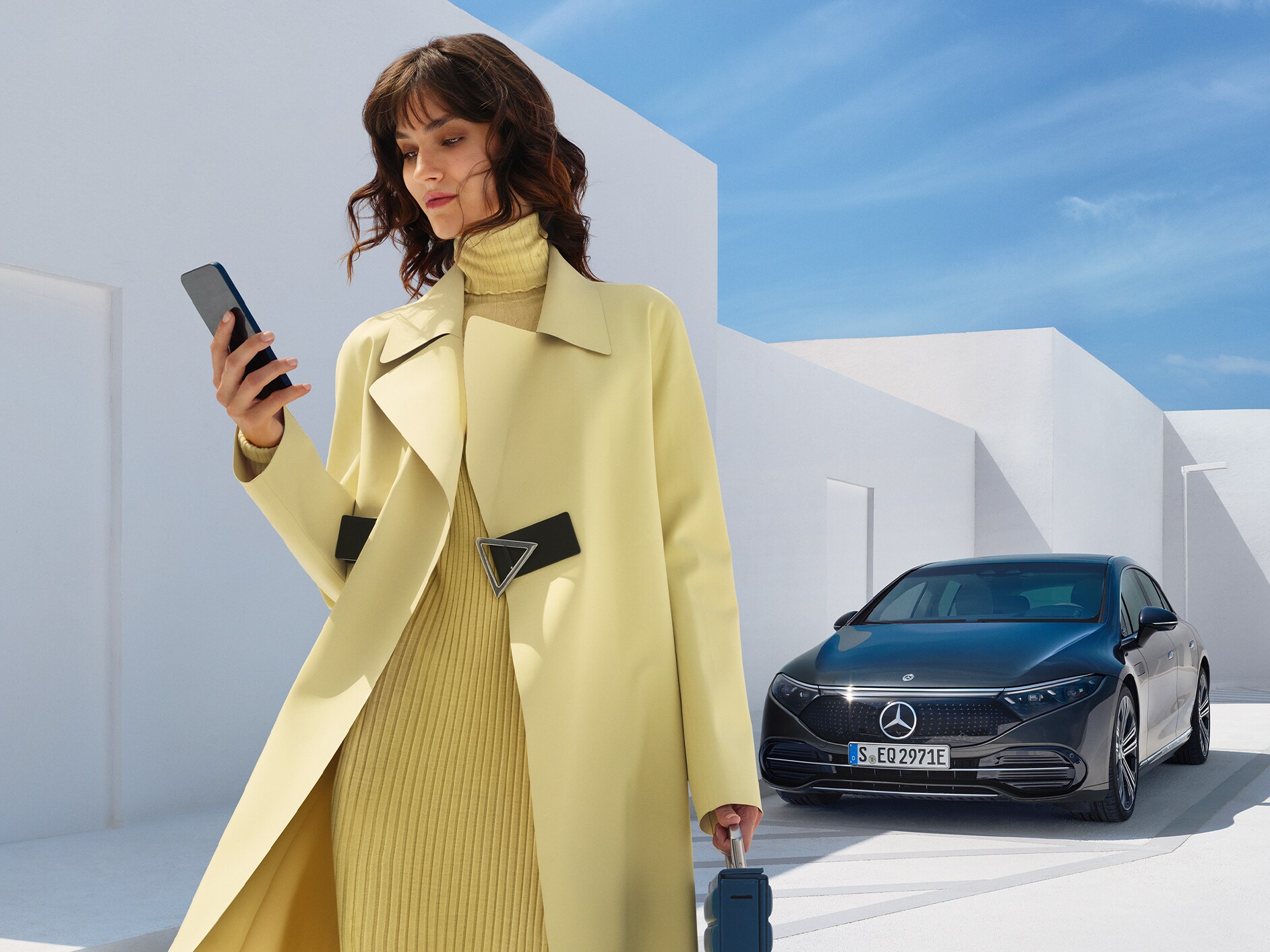 Das Bild zeigt eine Frau vor der EQS Limousine von Mercedes-EQ.
