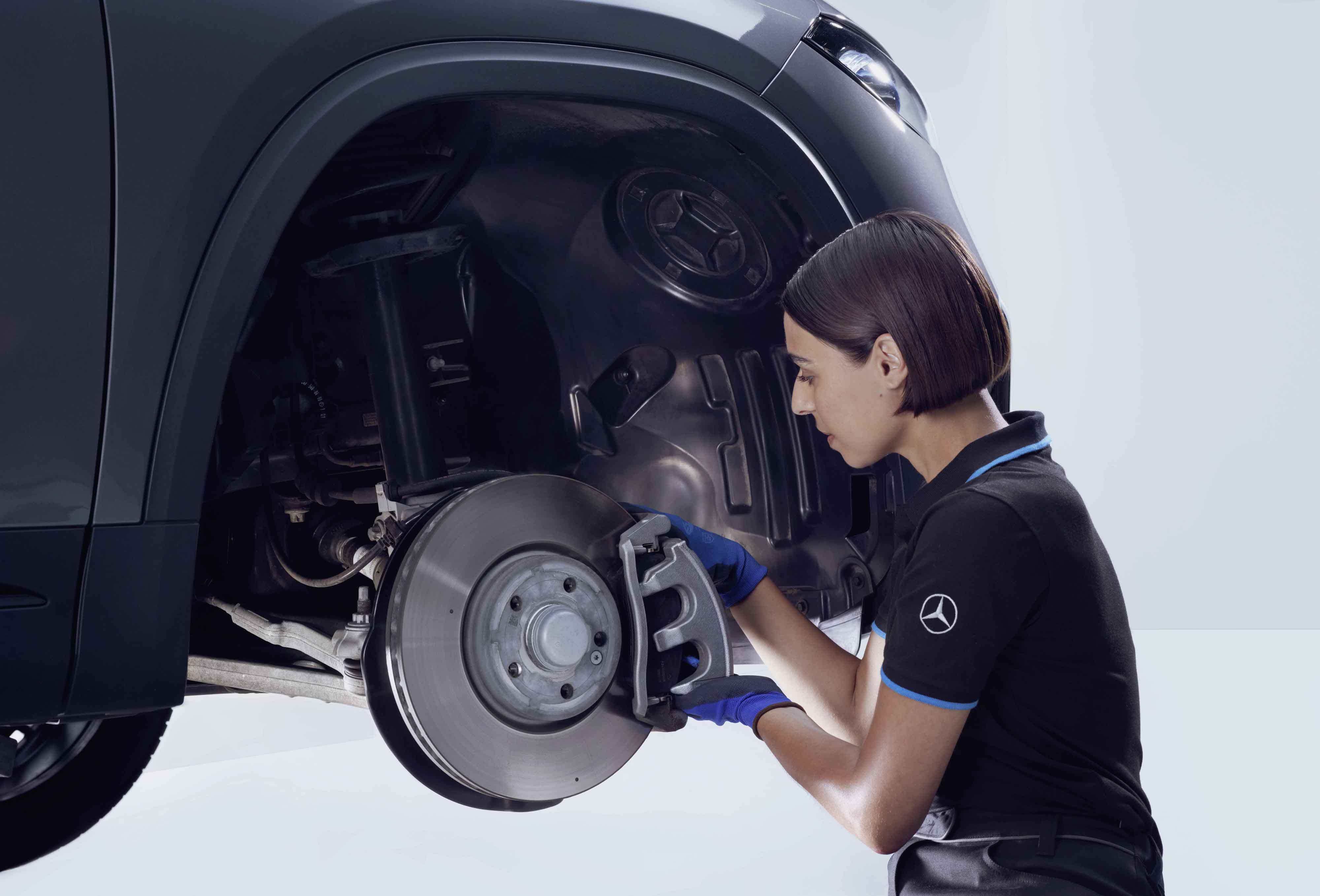 Brakes | Mercedes-Benz A person repairing the brakes of a Mercedes-Benz vehicle.