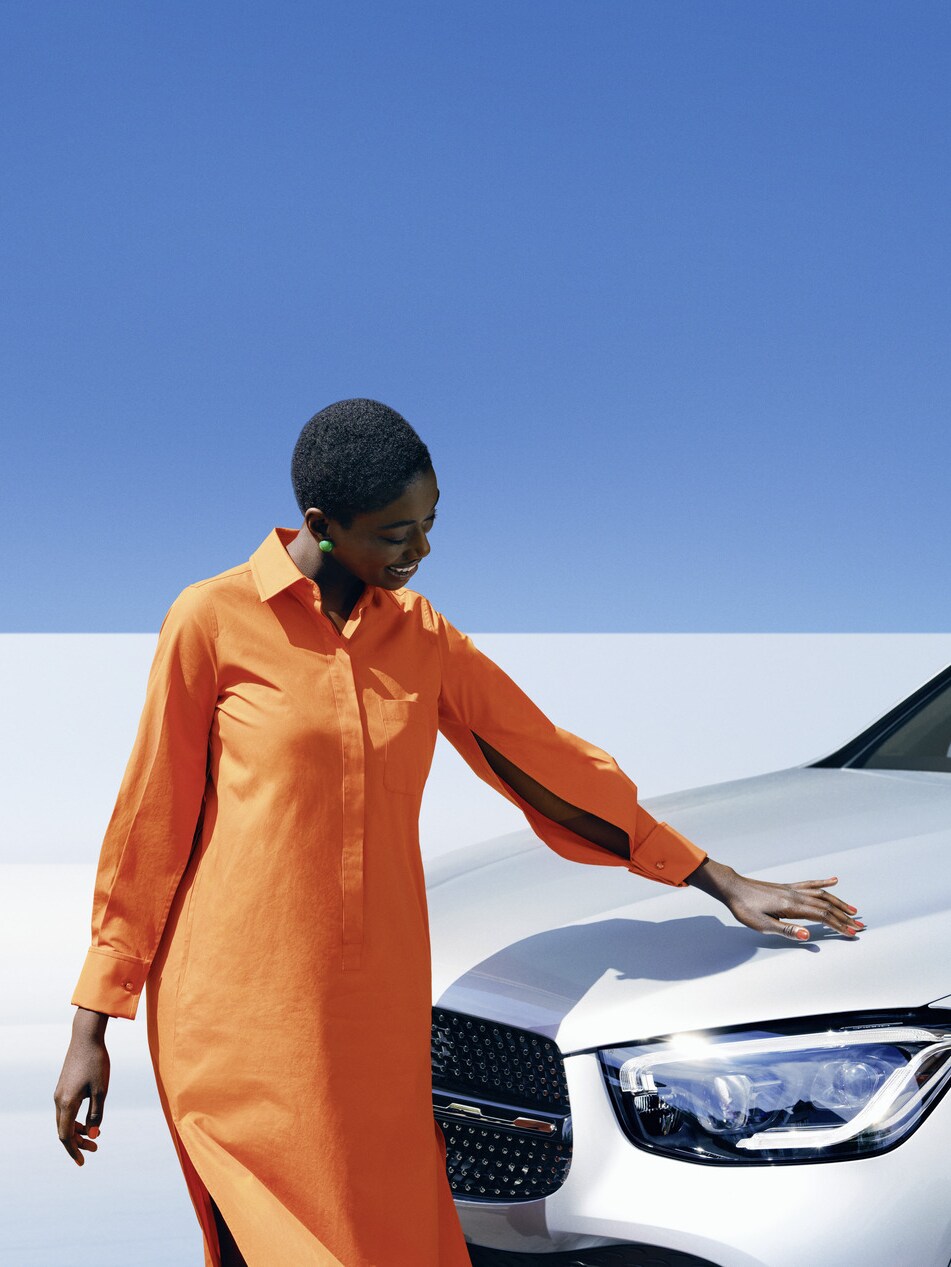 Eine Person steht neben einem Mercedes-Benz Fahrzeug.