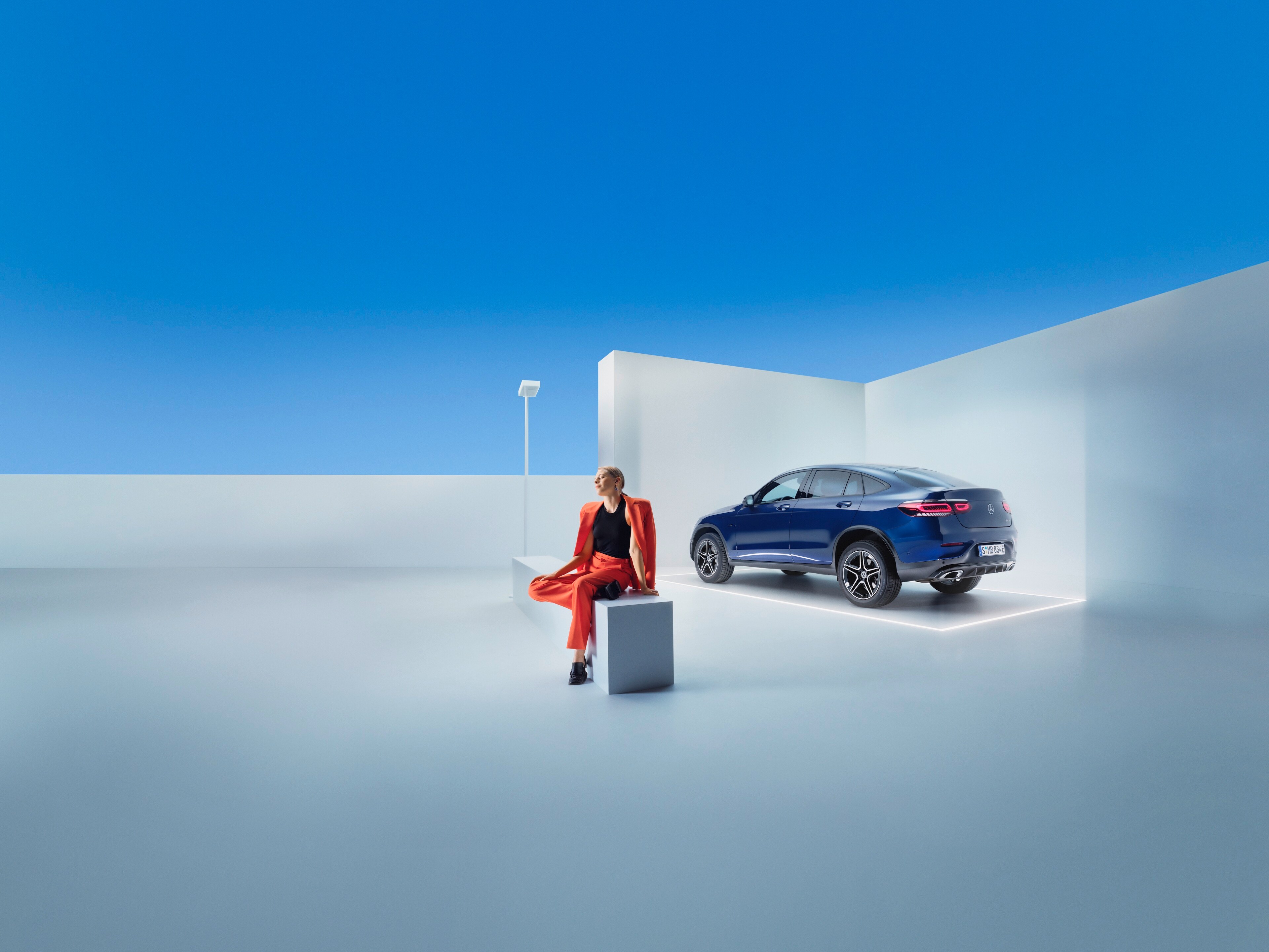 Eine Frau entspannt sich auf einer Bank vor ihrem Mercedes-Benz.