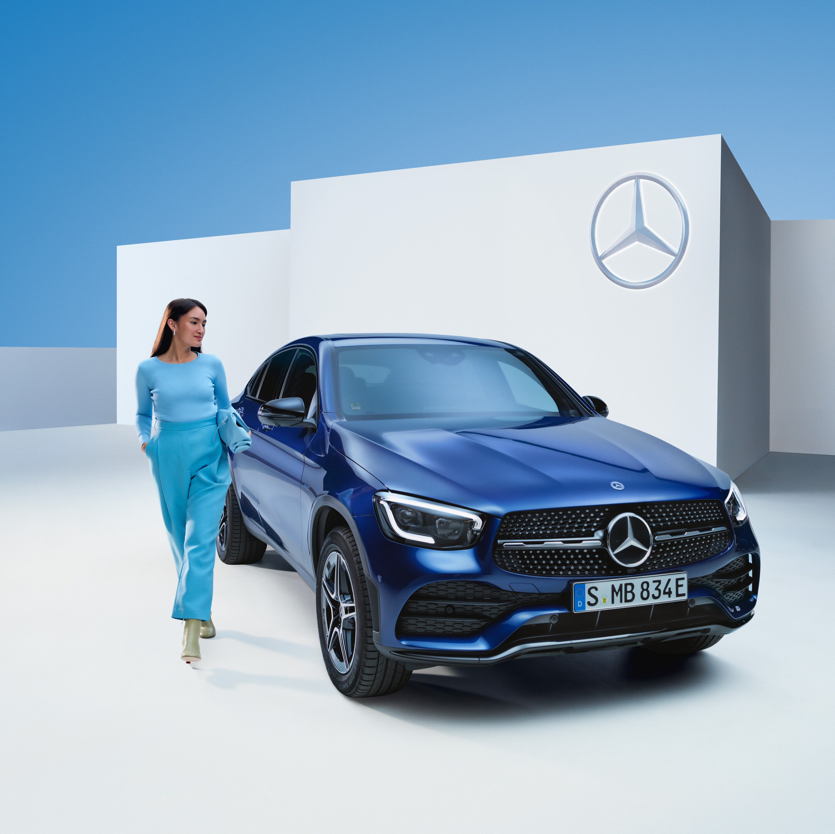 Eine gehende Person neben einem Mercedes-Benz Fahrzeug.