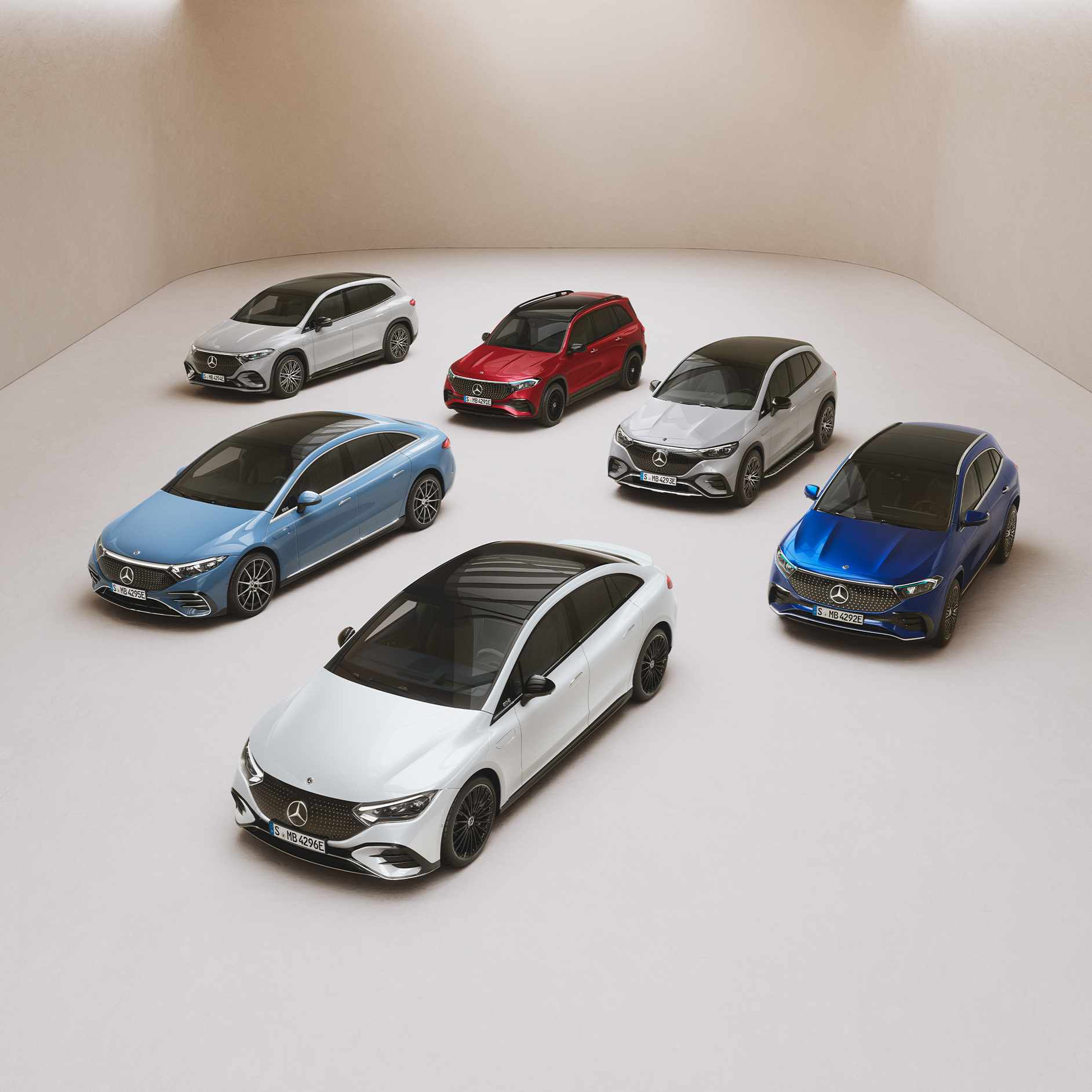 Die Modelle der EQ-Reihe von Mercedes-Benz. Die Modelle EQS Limousine, EQE Limousine, EQA, EQB und EQC stehen geparkt auf einer Spiegelfläche.