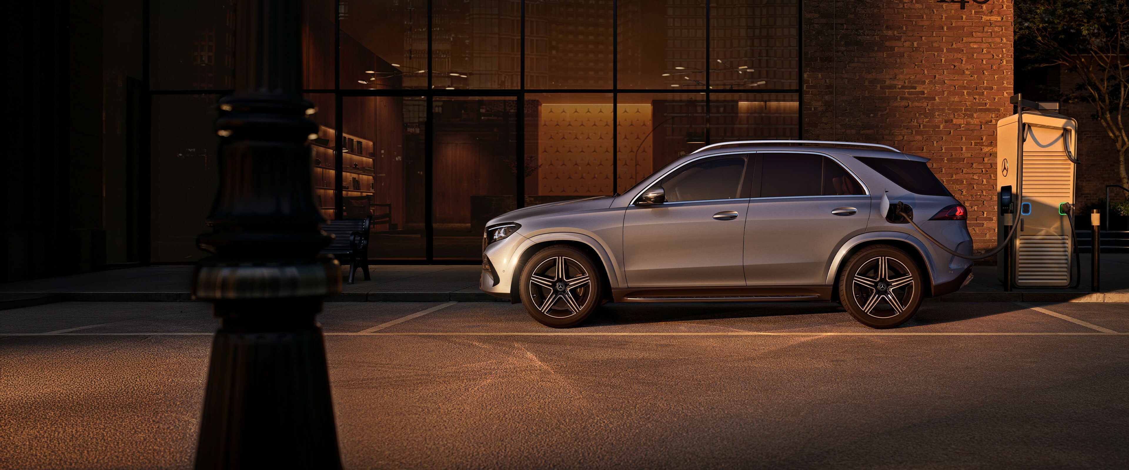Der Mercedes-Benz GLE SUV in einer Seitenansicht vor einem großen Haus.