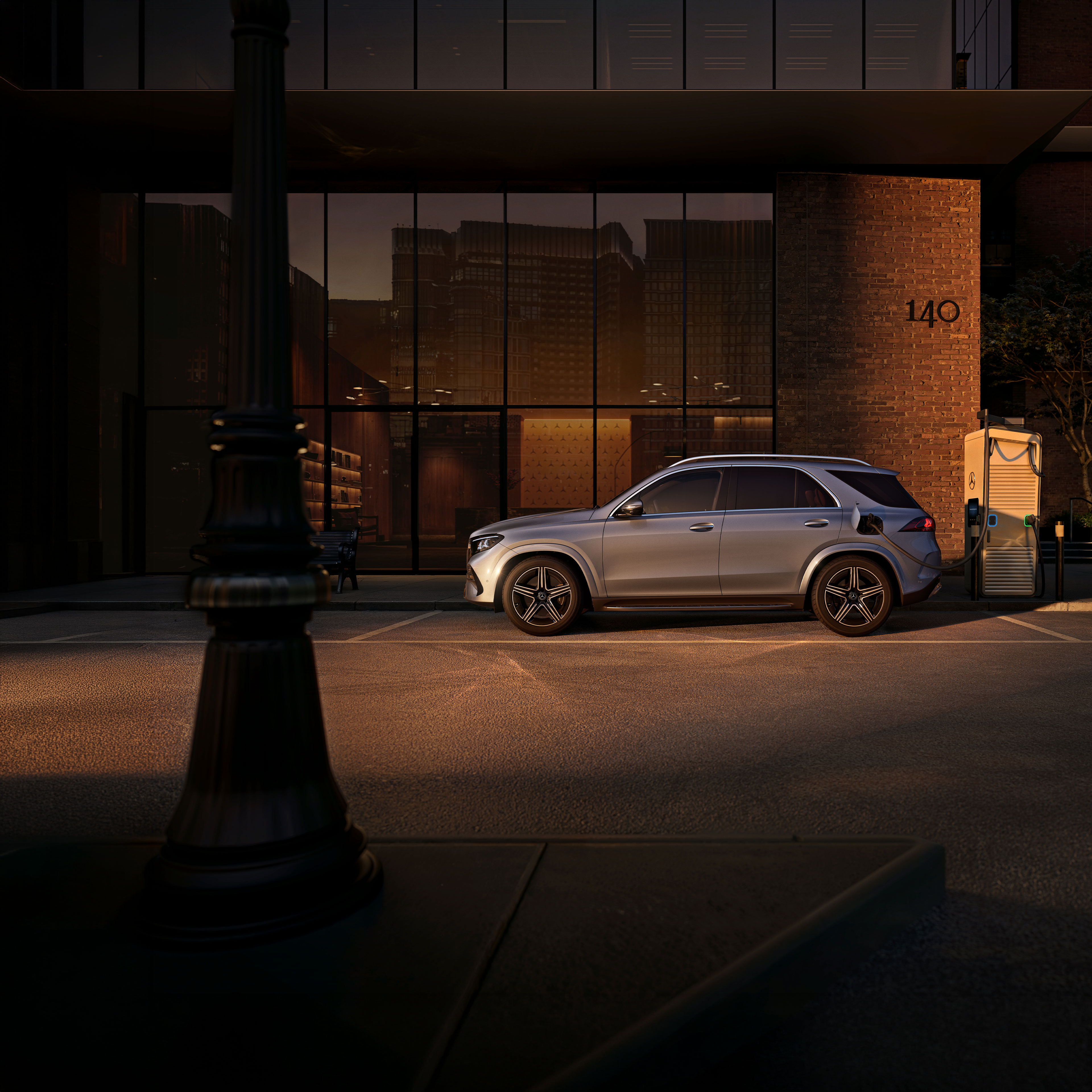 Plug-in-Hybride | Mercedes-Benz Der Mercedes-Benz GLE SUV in einer Seitenansicht vor einem großen Haus.