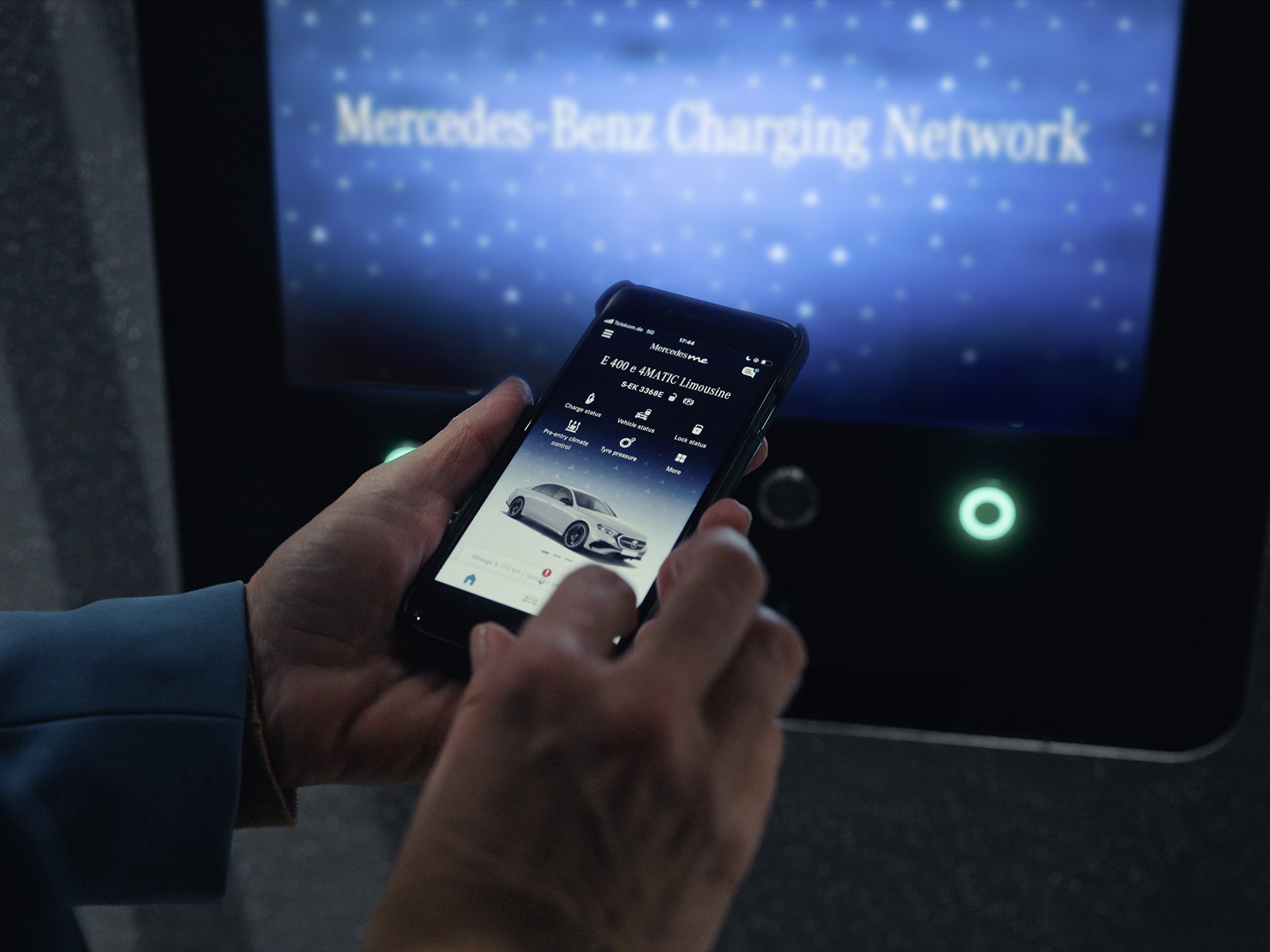 Lademöglichkeiten | Plug-in-Hybride | Mercedes-Benz Jemand hält ein Smartphone mit einer App in der Hand, die Lademöglichkeiten für Plug-in-Hybridfahrzeuge von Mercedes-Benz anzeigt.
