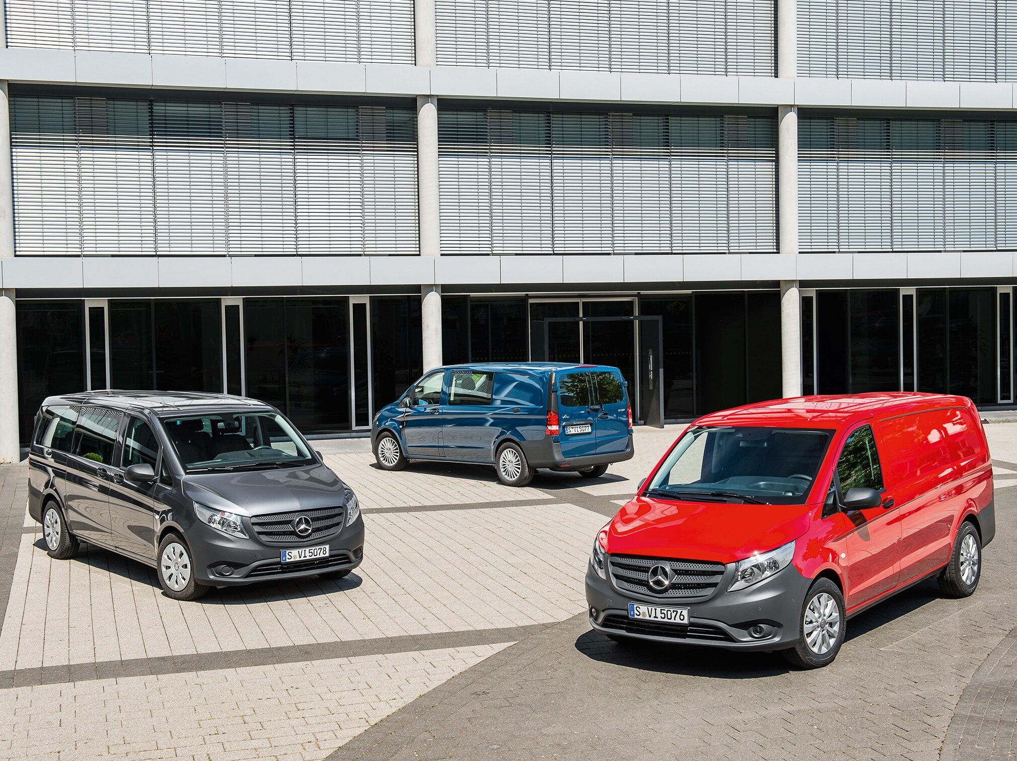 Vor einem modernen Bürogebäude stehen mehrere Mercedes-Benz Vito.
