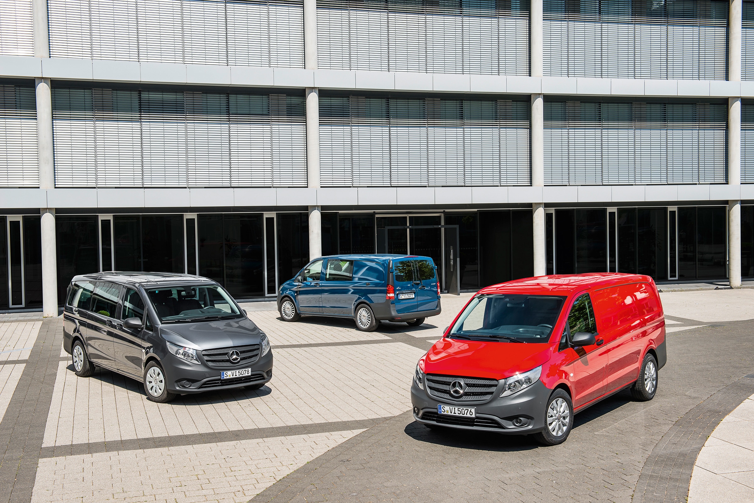 Die dritte Generation des Mercedes-Benz Vito | Geschichte der Nutzfahrzeuge | Mercedes-Benz Vor einem modernen Bürogebäude stehen mehrere Mercedes-Benz Vito.