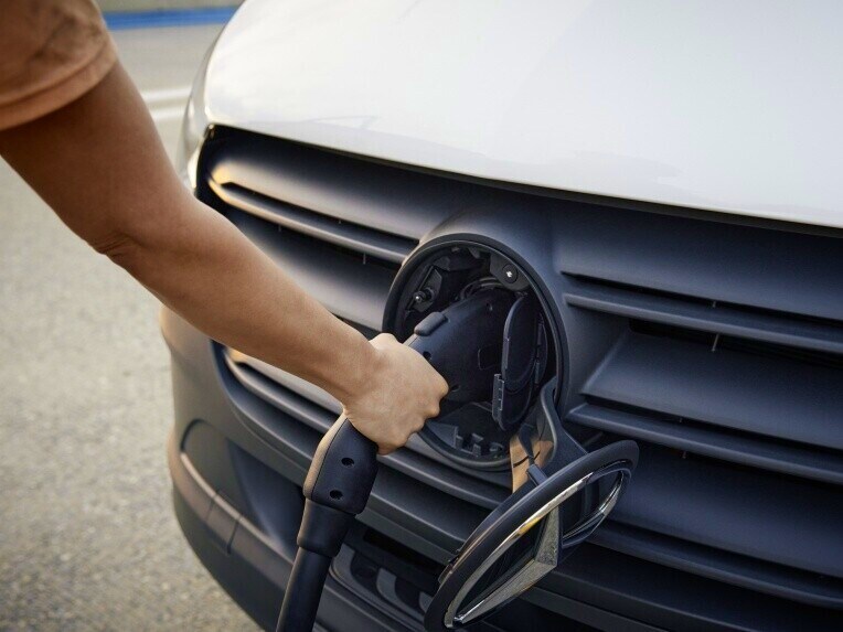 Die Ladedose des Mercedes-Benz eSprinter Kastenwagen mit gestecktem Ladekabel.