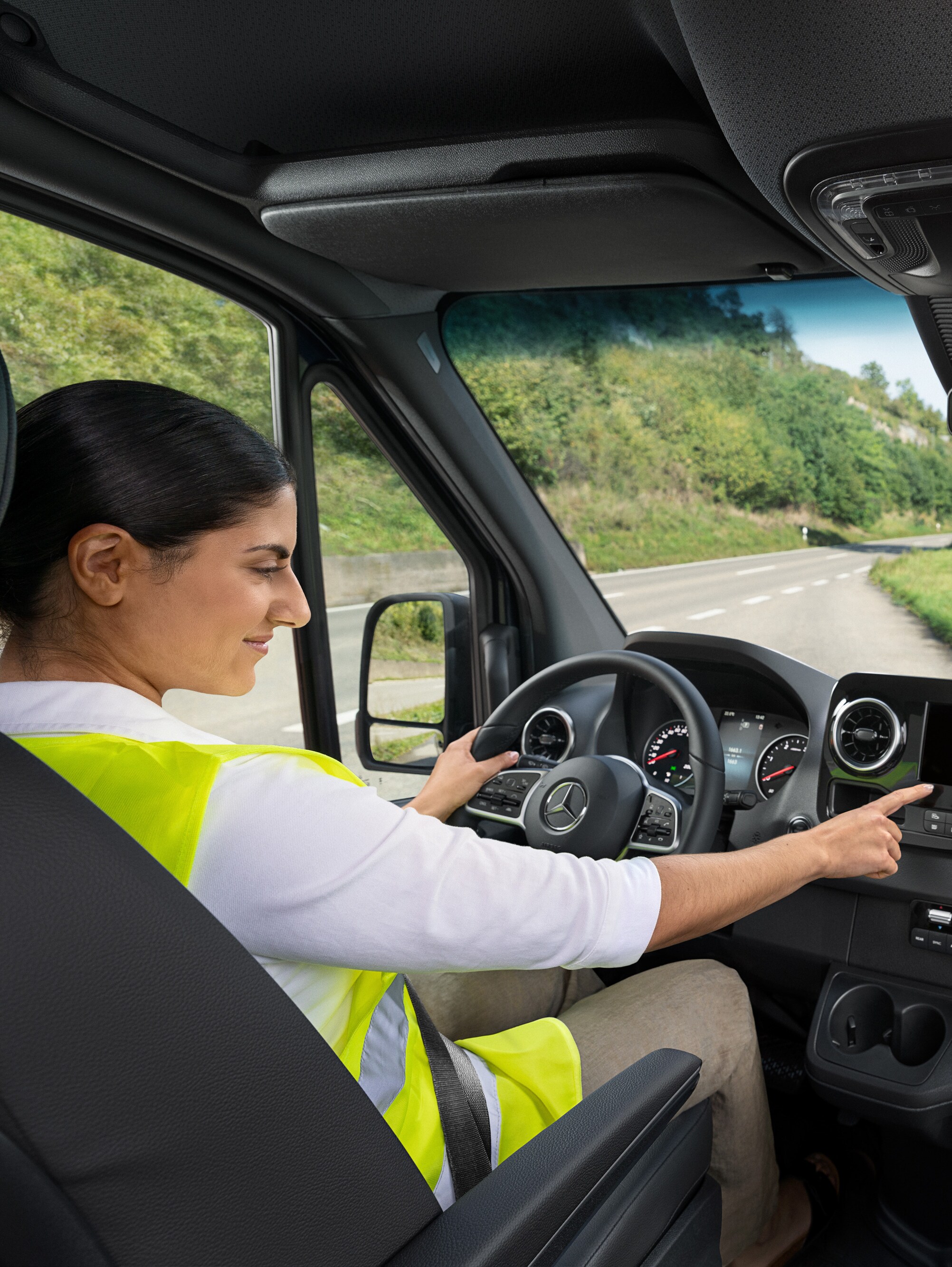 Die Fahrerin eines Mercedes-Benz Sprinters ruft bei Problemen über das Bordmenü die Mercedes-Benz Service24h-Hotline an.
