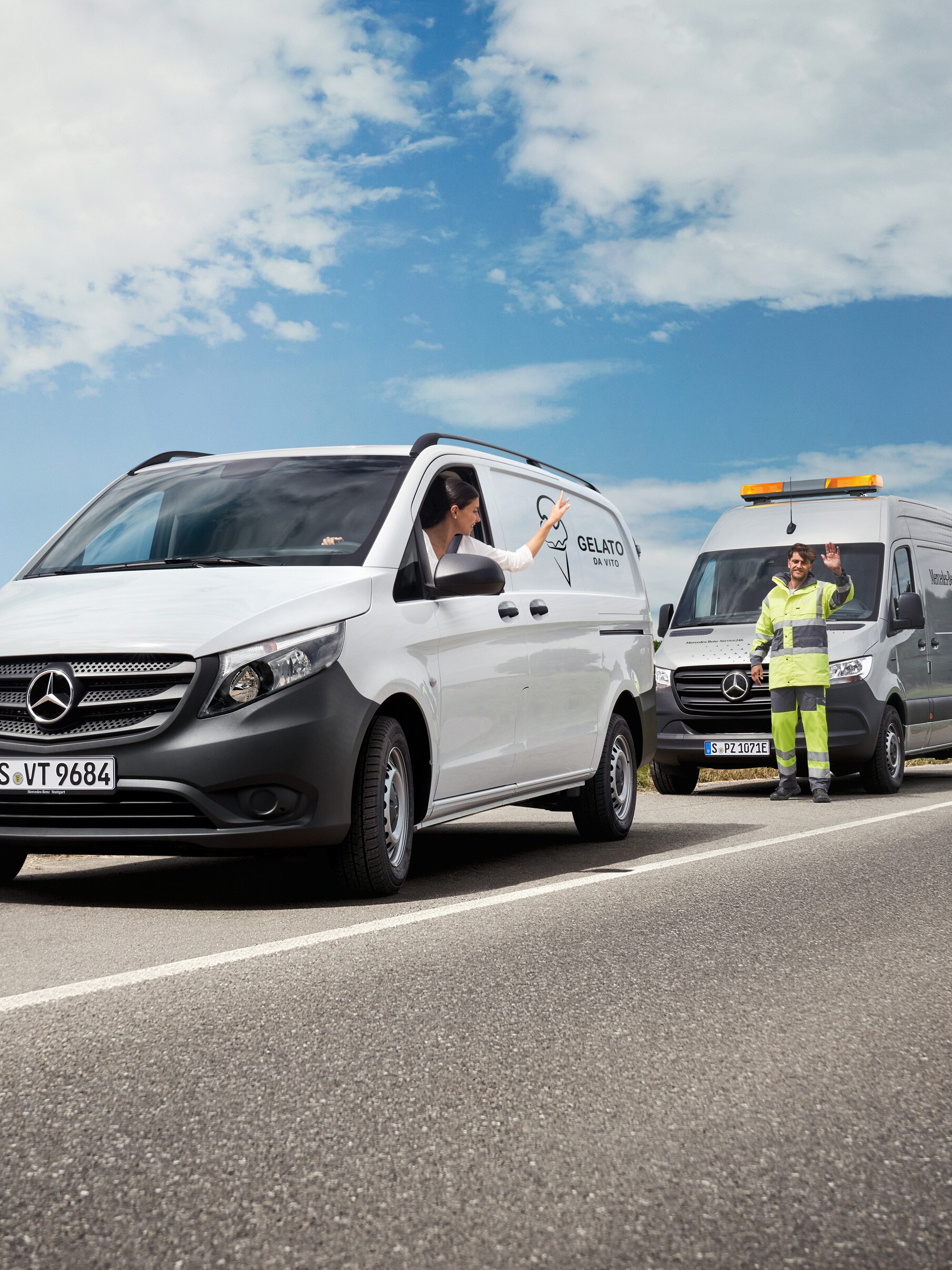 Eine Person in einem weißen Mercedes-Benz Vito Transporter winkt einem am Straßenrand geparkten Servicetechniker zu.