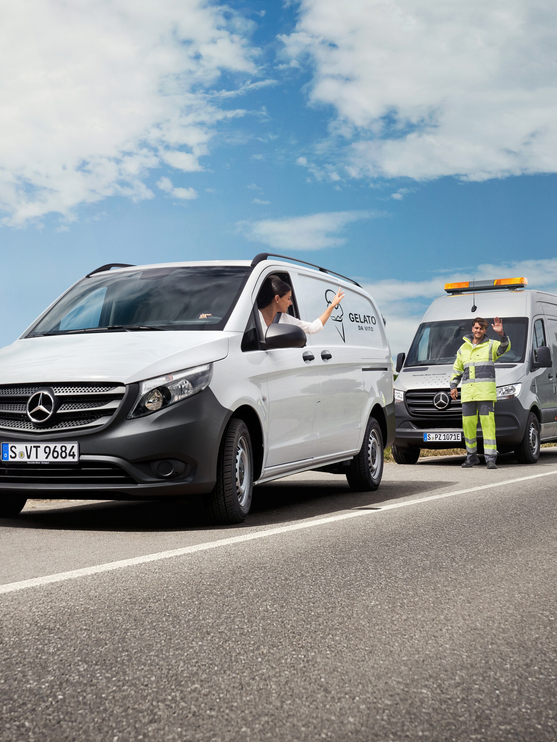Eine Frau sitzt in einem weißen Mercedes-Benz Vito und winkt einem Mercedes-Benz Servicetechniker am Straßenrand zu.