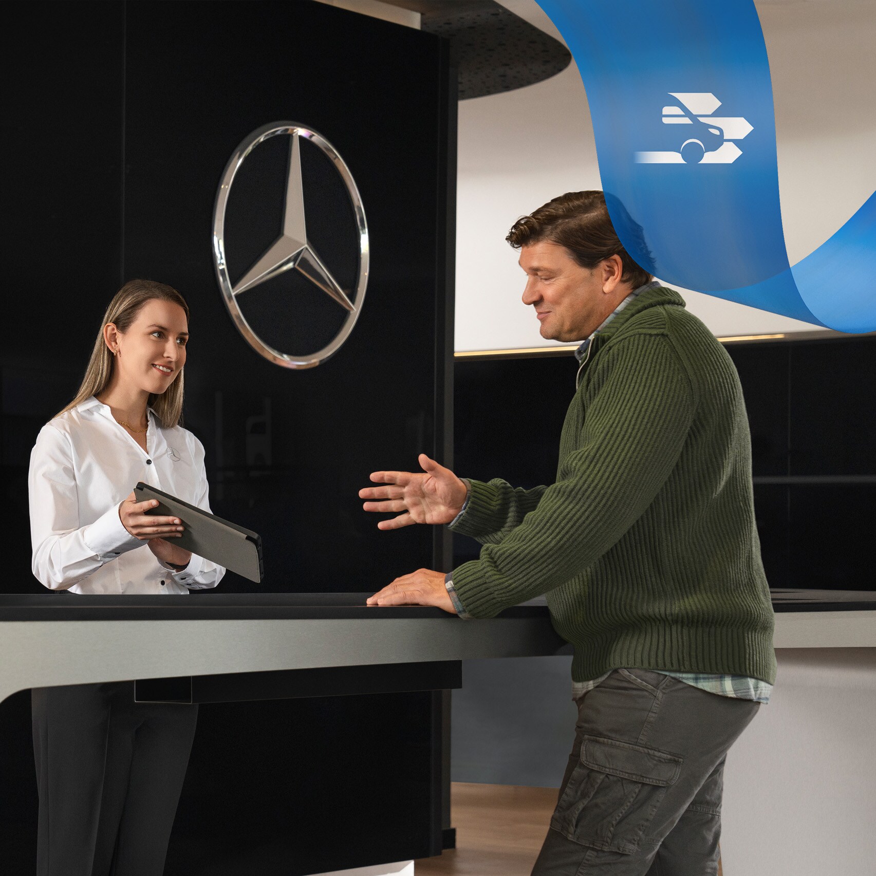 Ein Mercedes-Benz Mitarbeiter betreut einen Kunden an der Rezeption.