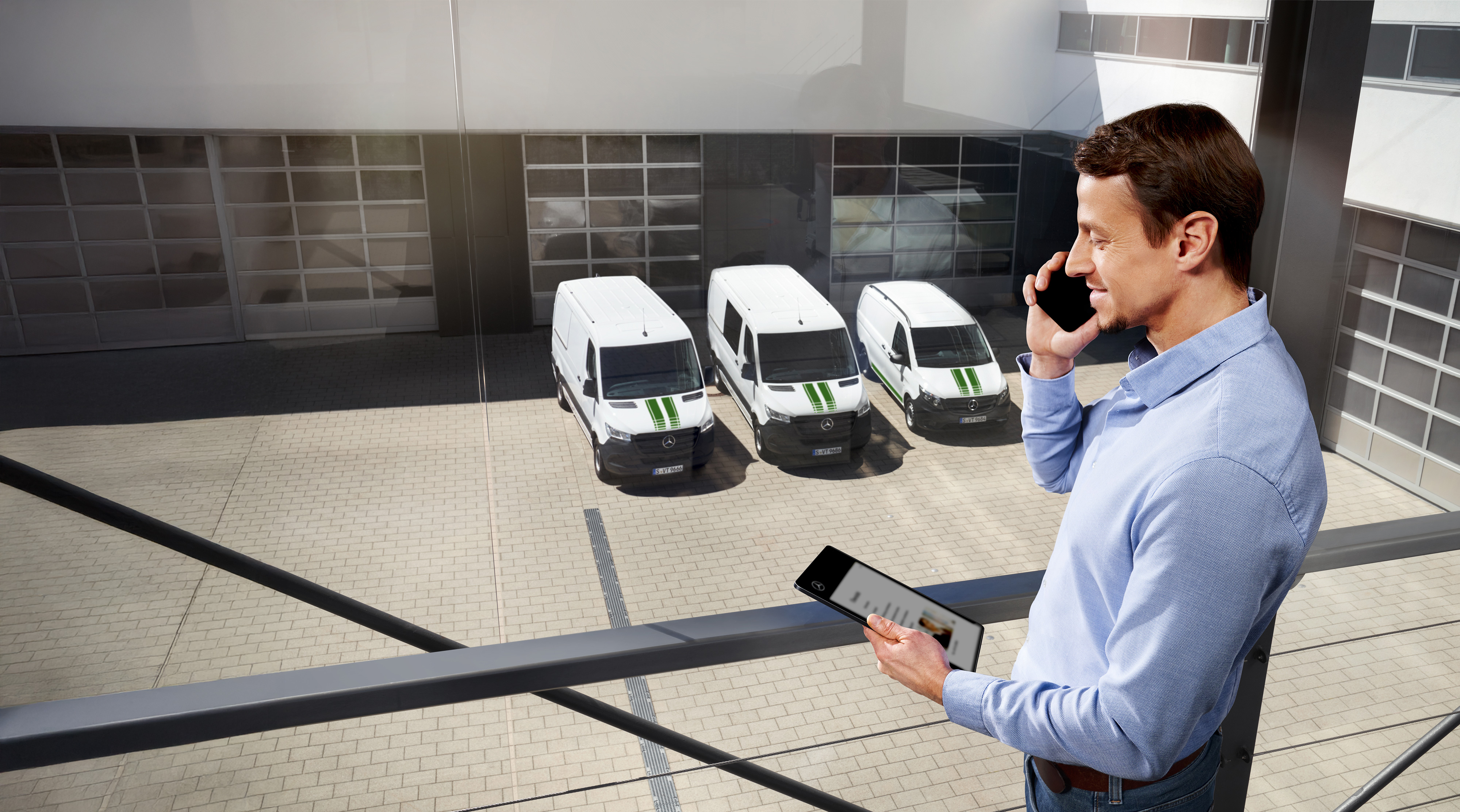 Mercedes Benz | Convenience Mobilovan Customer on the phone in front of a fleet of white Mercedes-Benz vans.