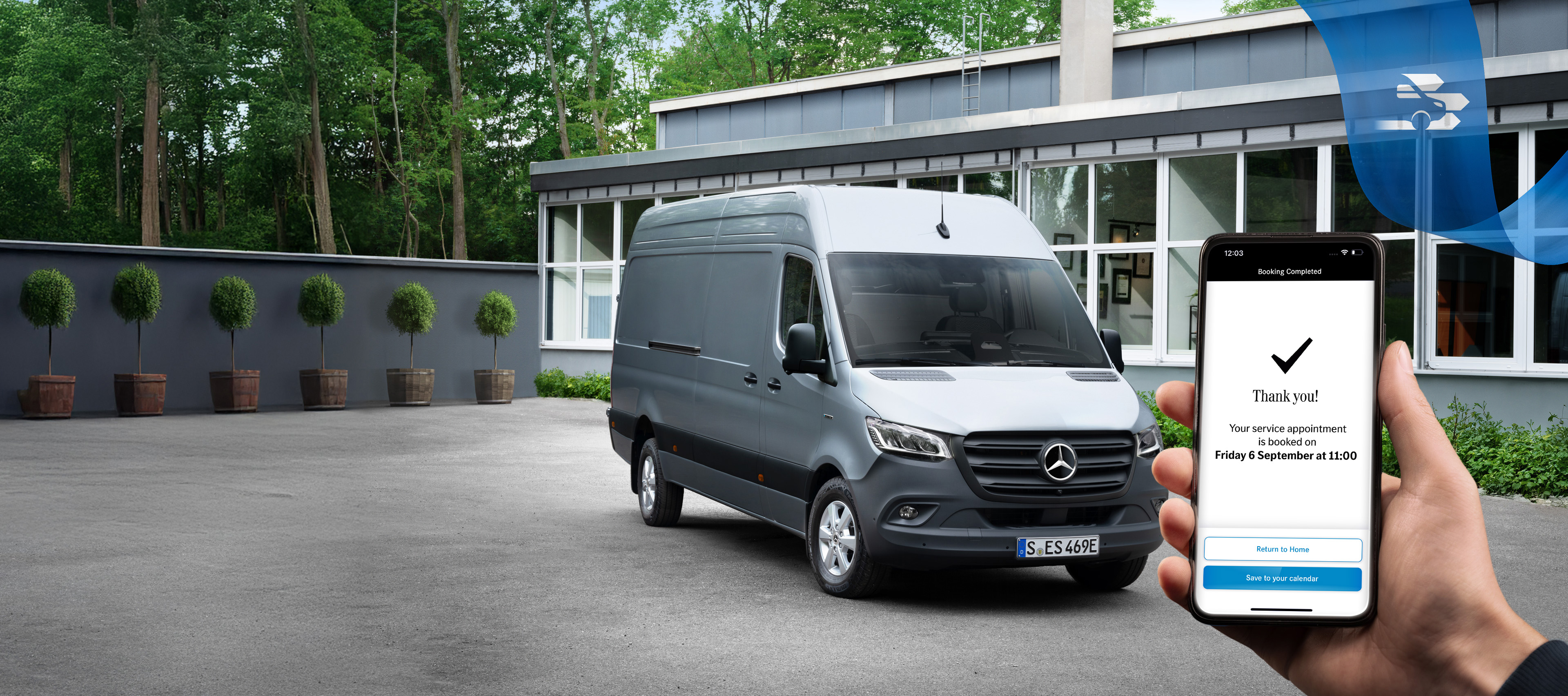 Mercedes-Benz | Komfort | Online-Terminbuchung Ein grauer Mercedes-Benz Sprinter Transporter vor einem Bürogebäude mit einer Hand, die ein Smartphone hält im Vordergrund.