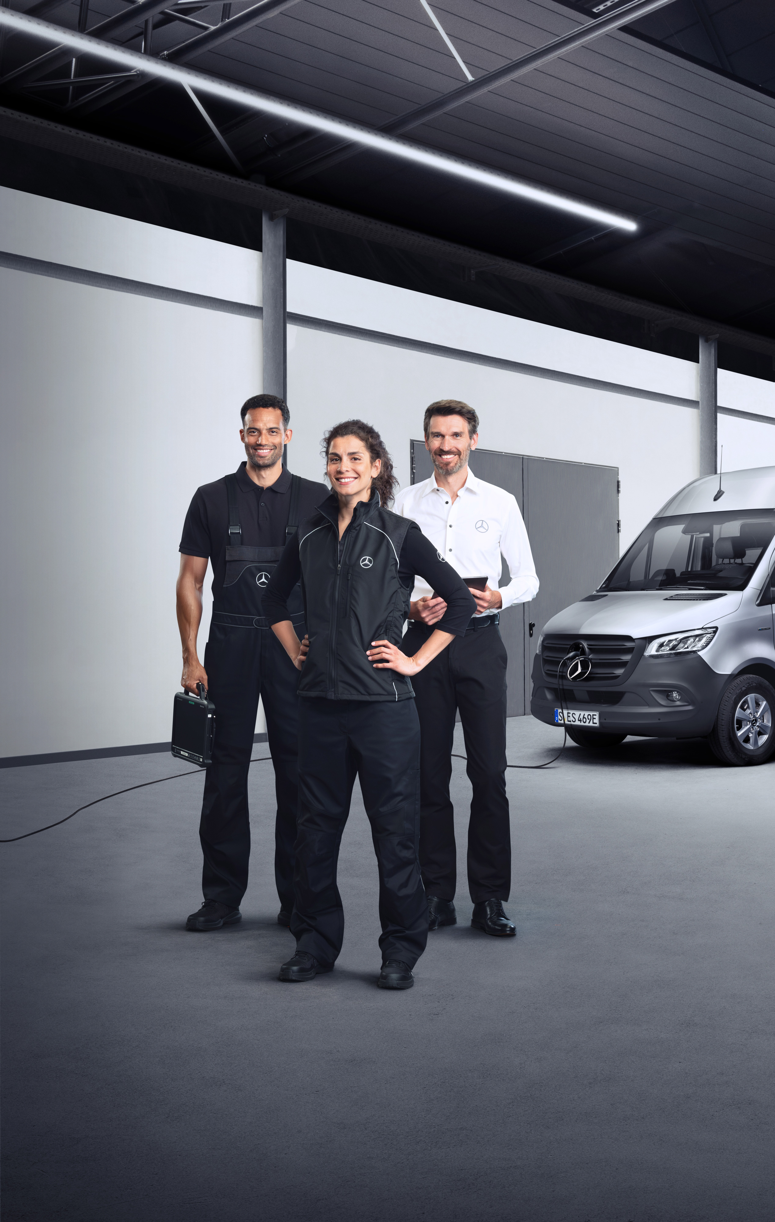 Mercedes-Benz | Elektrofahrzeug-Service Drei Mitarbeiter vor einem elektrischen Mercedes-Benz Sprinter mit angeschlossenem Ladekabel.