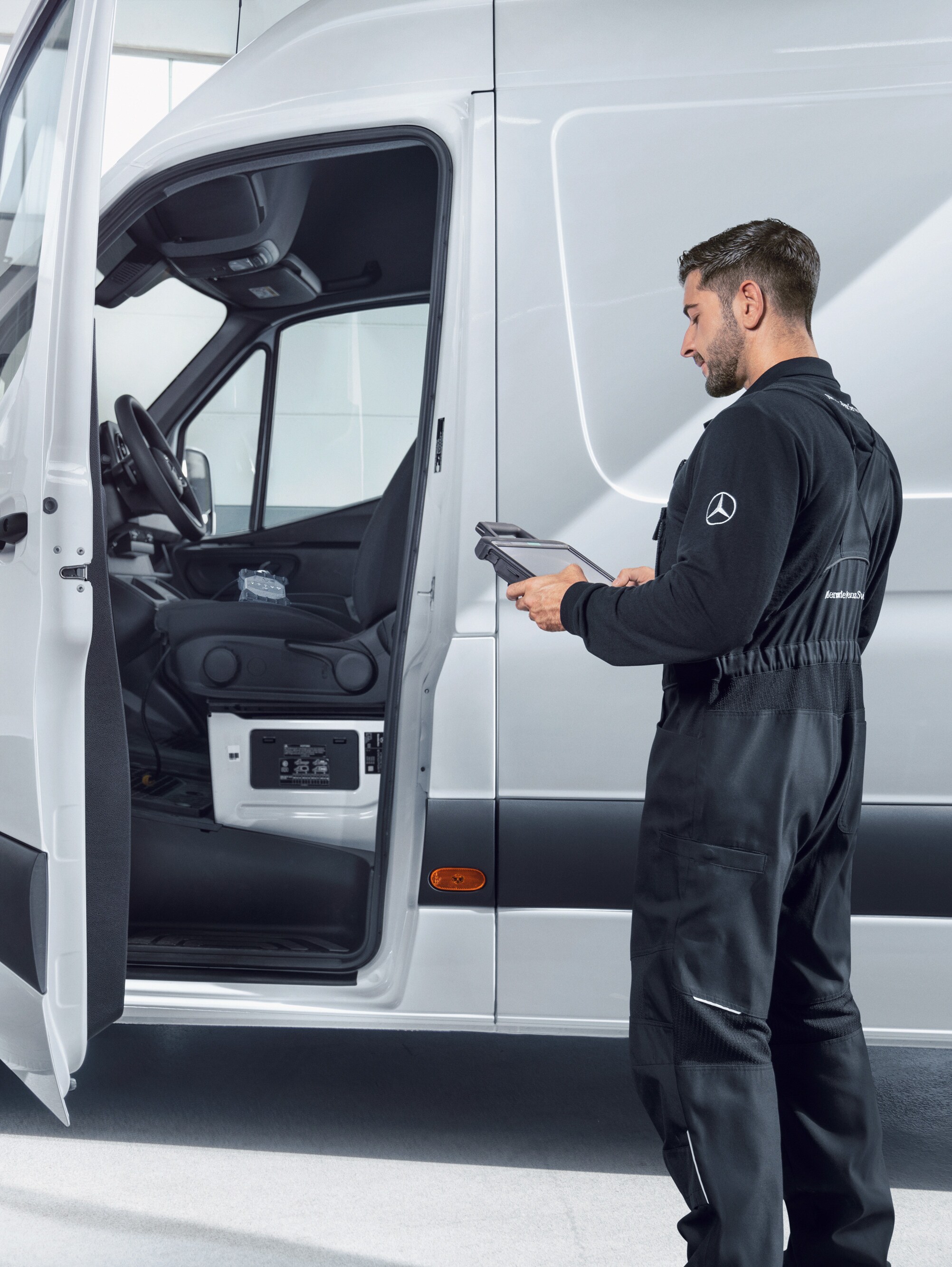 Ein Mitarbeiter inspiziert einen Mercedes-Benz Transporter, der zuverlässige Servicequalität bei Wartung und Reparatur bietet.