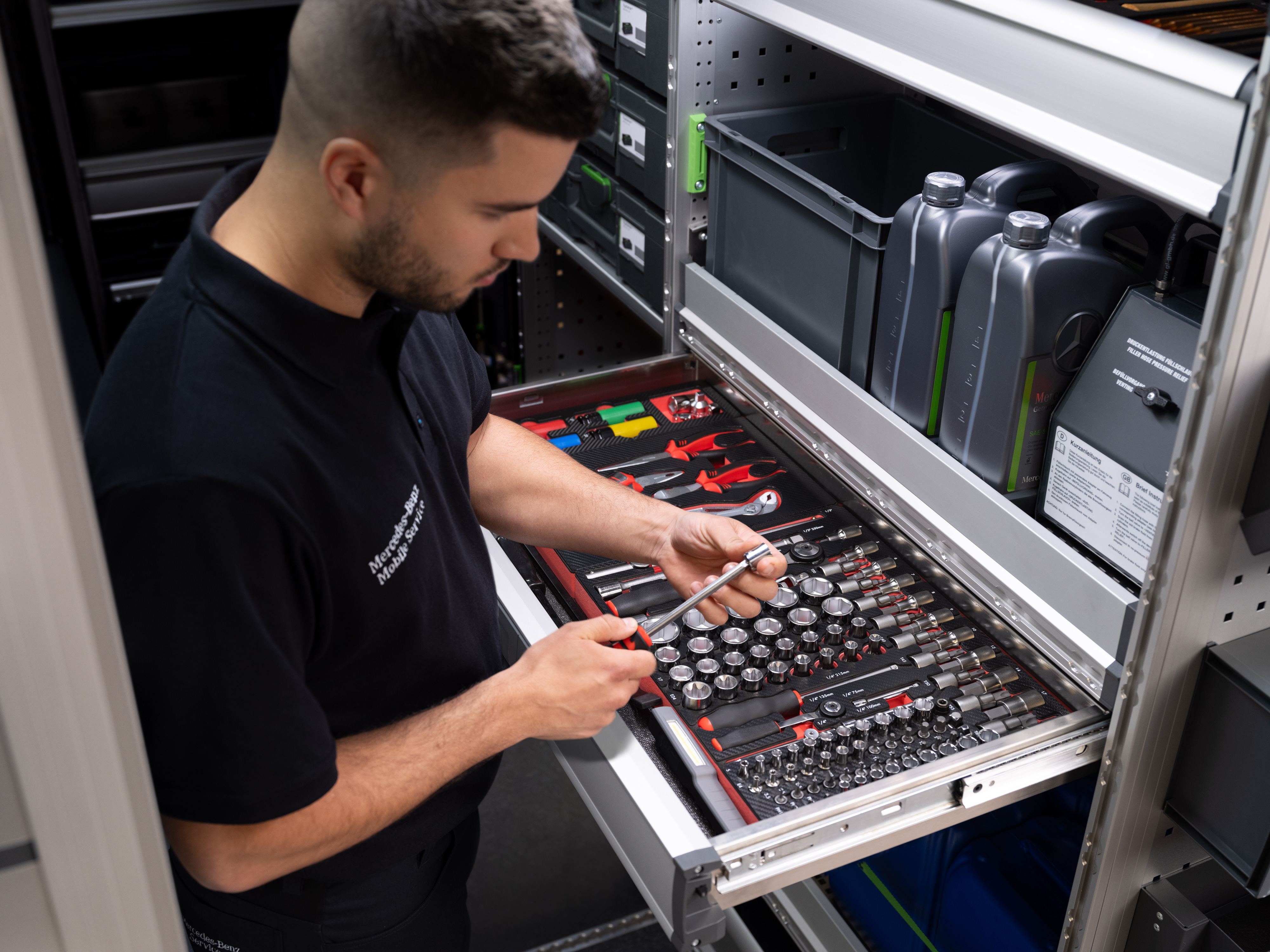 Mercedes-Benz | Mobiler Service | Elektronik Ein Techniker wählt einen Gegenstand aus einer Schublade voller Werkzeuge aus.