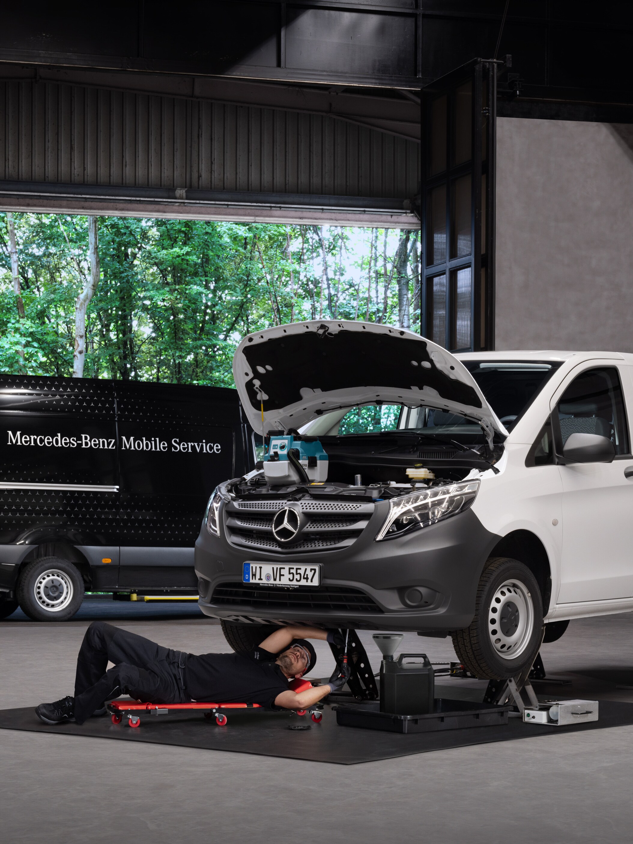 Ein Techniker repariert einen weißen Mercedes-Benz Vito.